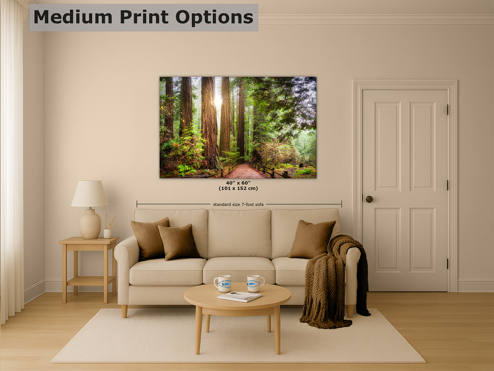 A wall art print showing a sunlit California Redwood forest path between tall trees, displayed above a beige sofa in a styled living room.
