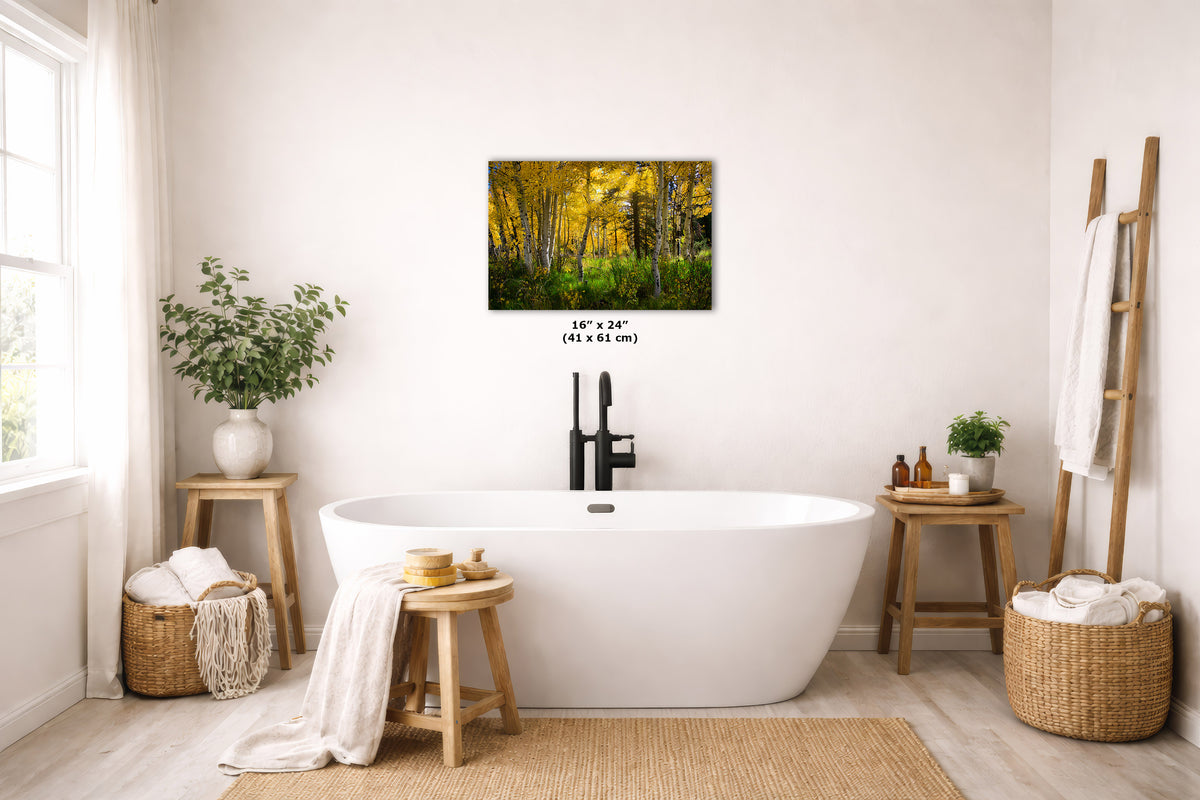 A freestanding bathtub in a bright, modern bathroom with a wall-mounted city skyline art print above it. The room includes wooden stools, woven baskets, plants, and a ladder shelf with towels.