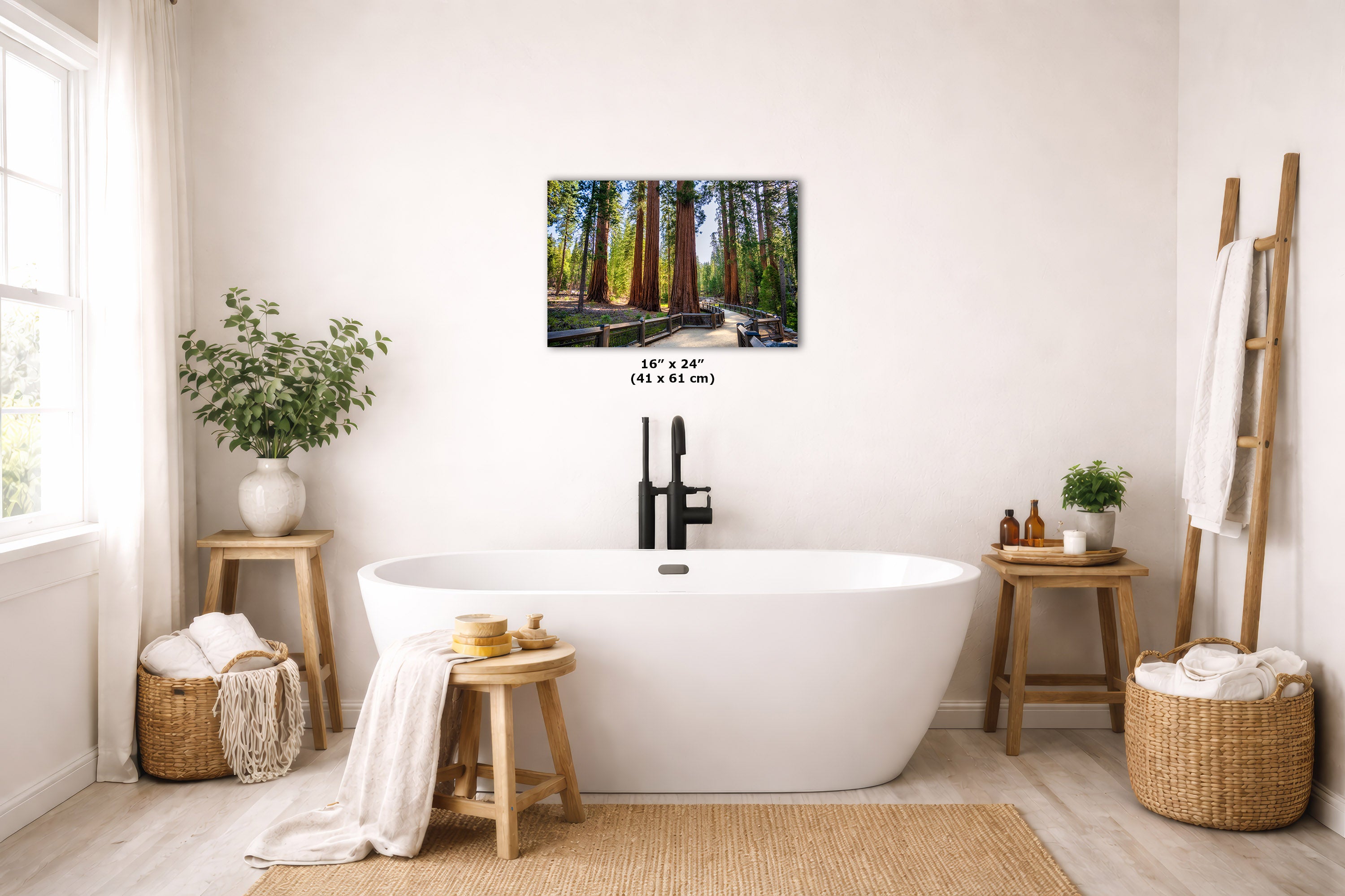 A framed vertical landscape art print depicting giant redwood trees in a forest, displayed on a light beige wall above a white freestanding bathtub in a styled, bright bathroom setting.