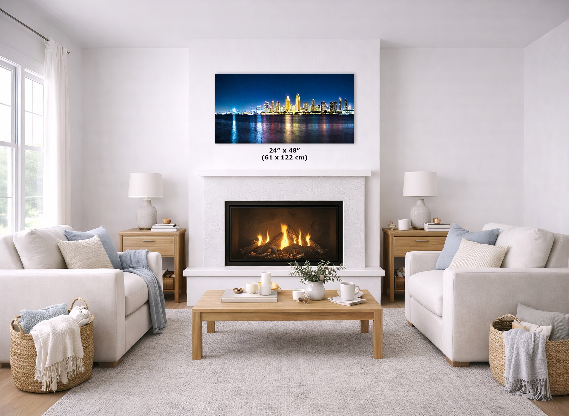 A framed wall art print showing a nighttime city skyline over water, displayed above a fireplace in a bright, modern living room with two white sofas, a wooden coffee table, and side tables.
