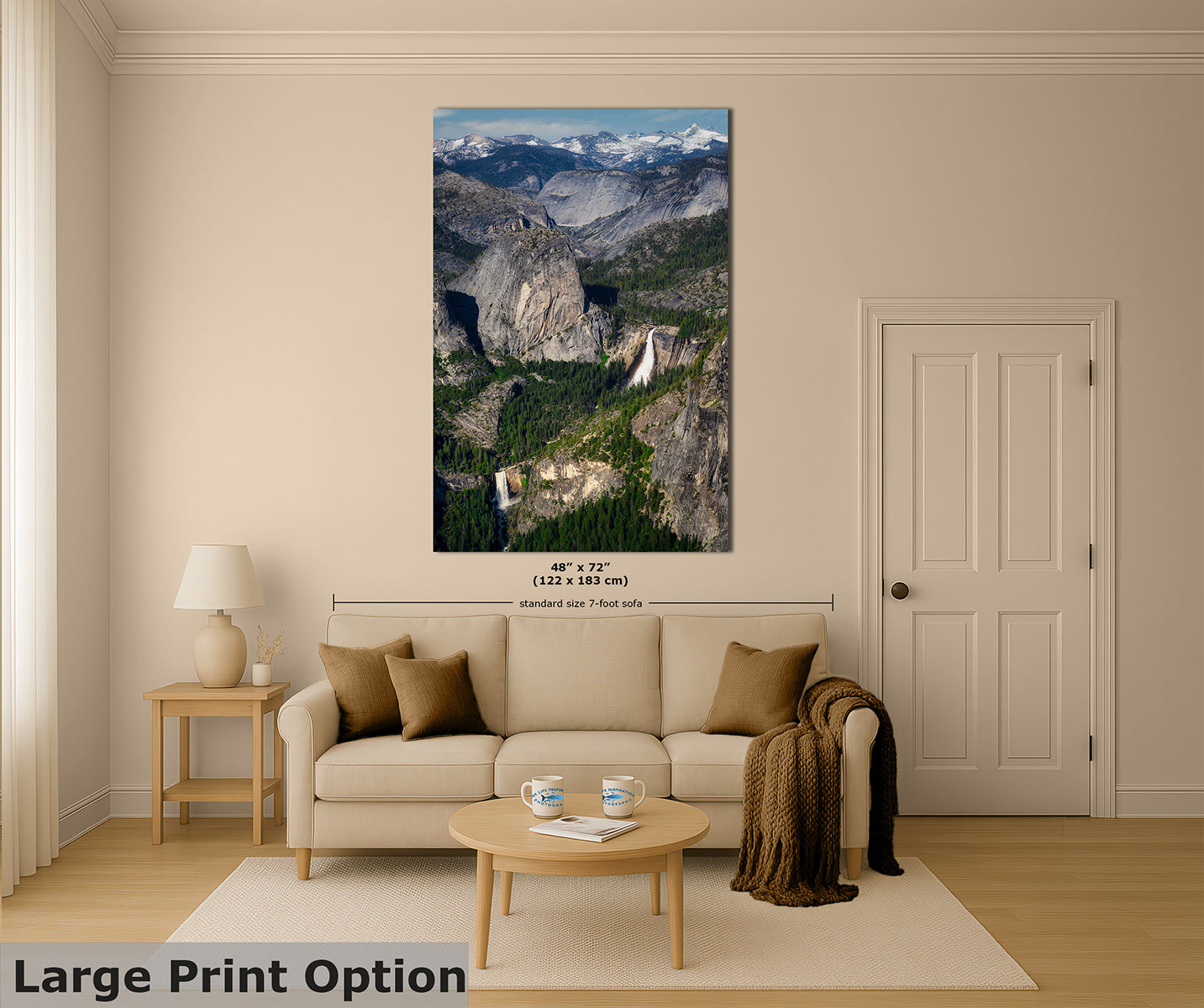 A large vertical Yosemite wall art print showing a mountain valley landscape with snowy peaks and Nevada and Vernal waterfalls, displayed above a beige sofa in a styled living room. The print includes size text reading 48" x 72".