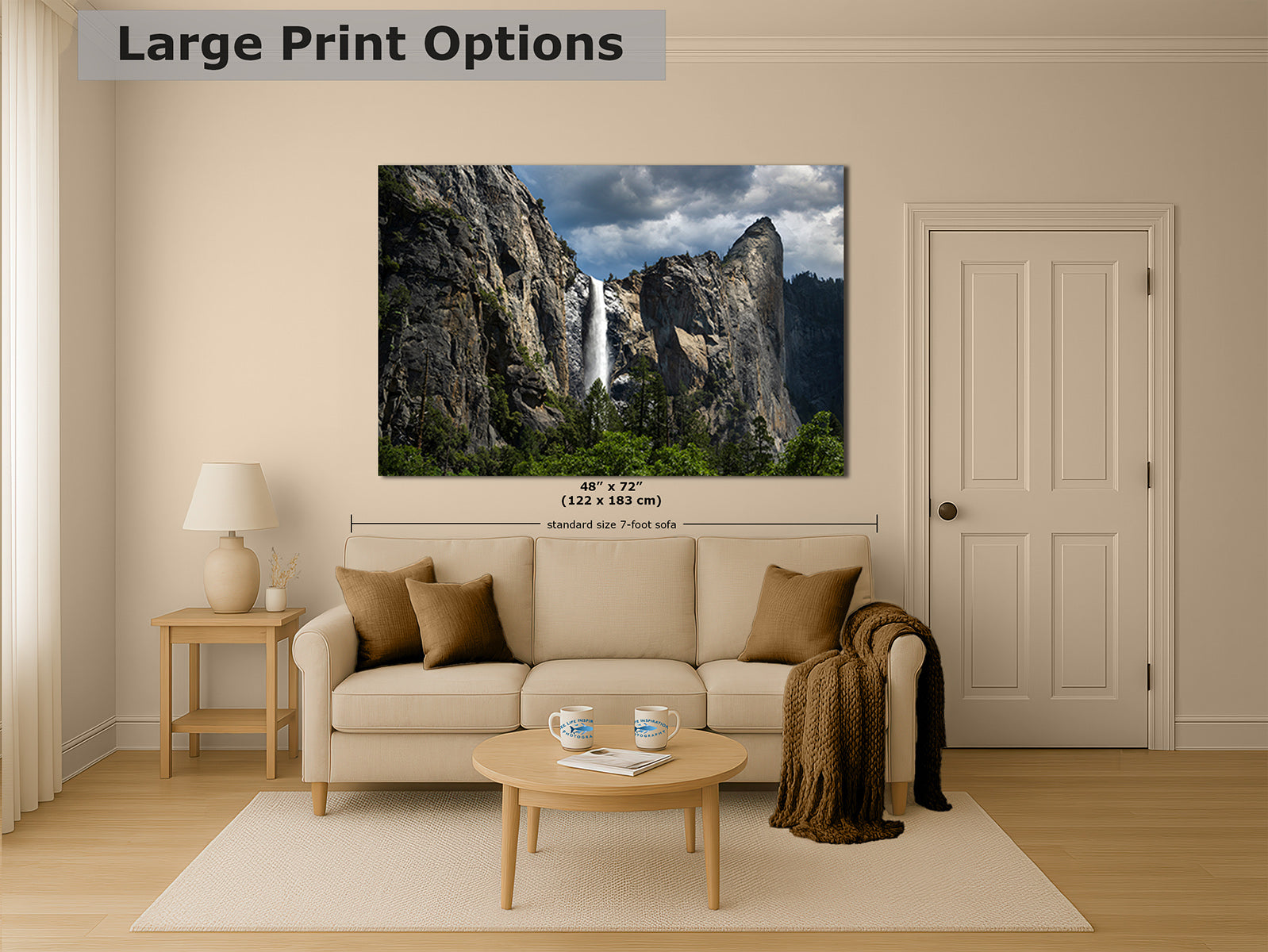 A large wall art print showing a mountain landscape with Yosemite's Bridalveil waterfall, displayed above a beige sofa in a styled living room. The image includes text reading 'Large Print Options' and size information for the print.