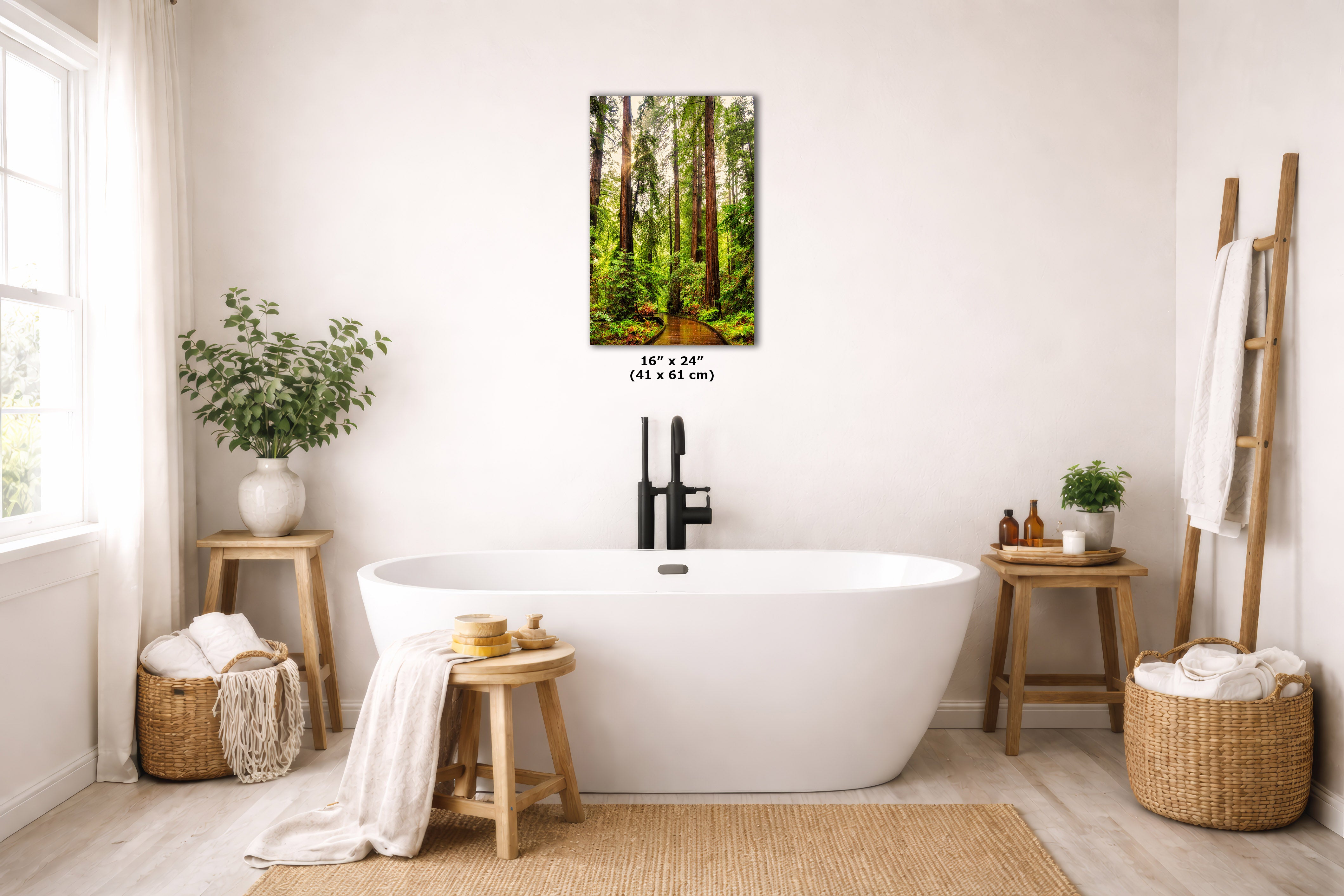 A vertical wall art print depicting a lush green forest, styled in a bright, modern bathroom above a white freestanding bathtub. The print includes a size dimension overlay of 16 x 24 inches (41 x 61 cm).