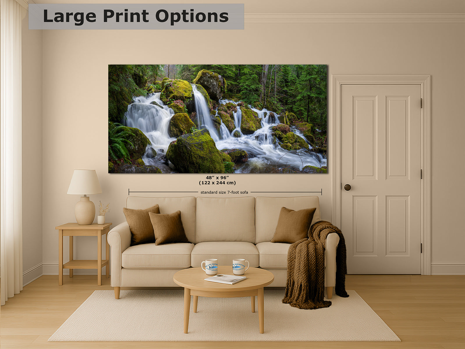 A large wall art print showing a forest waterfall scene, displayed above a beige sofa in a styled living room. The image includes text reading 'Large Print Options' and size information for the print.