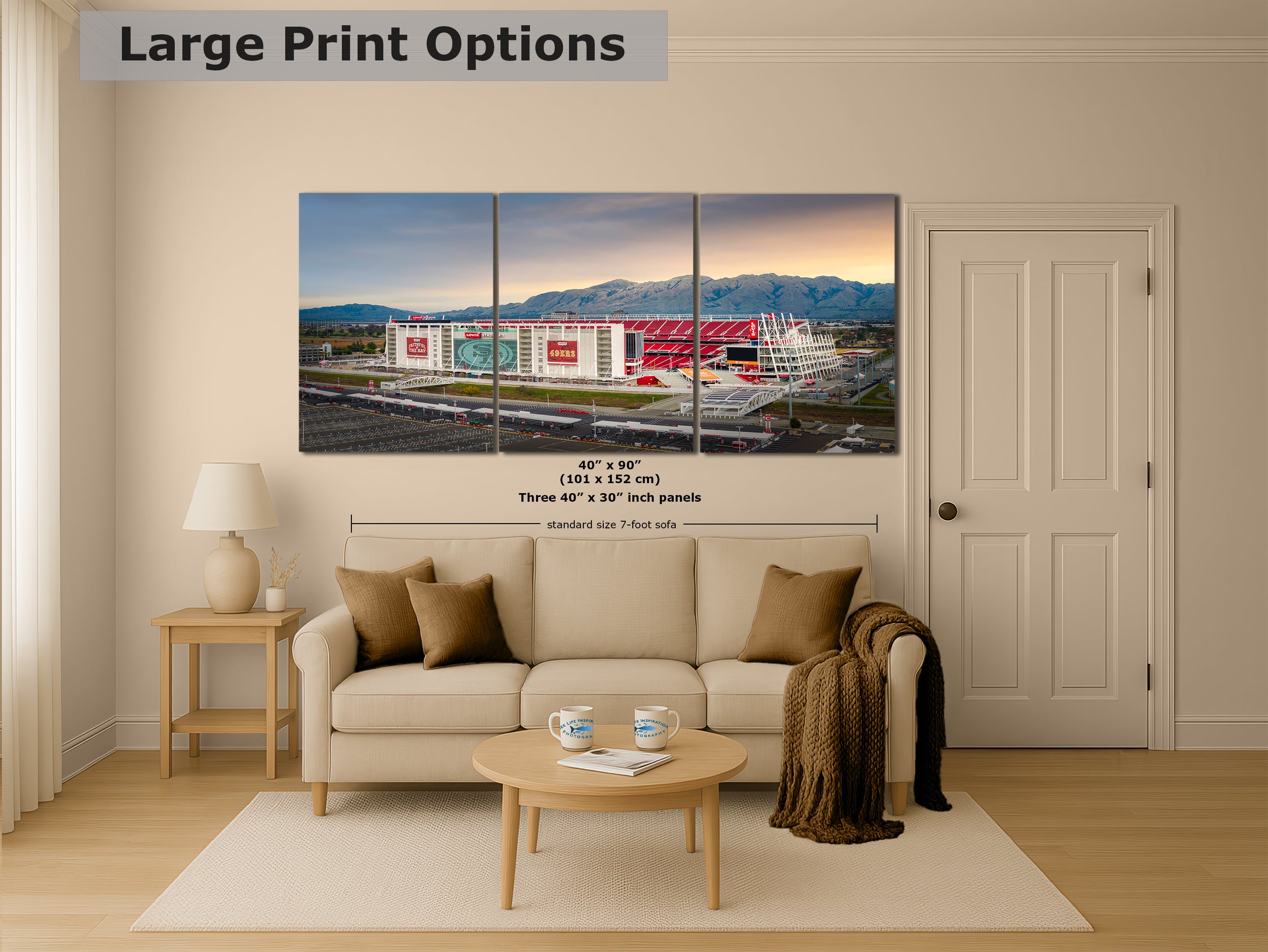 A living room with a large, colorful, three-panel print of a stadium or sports arena displayed on the wall.