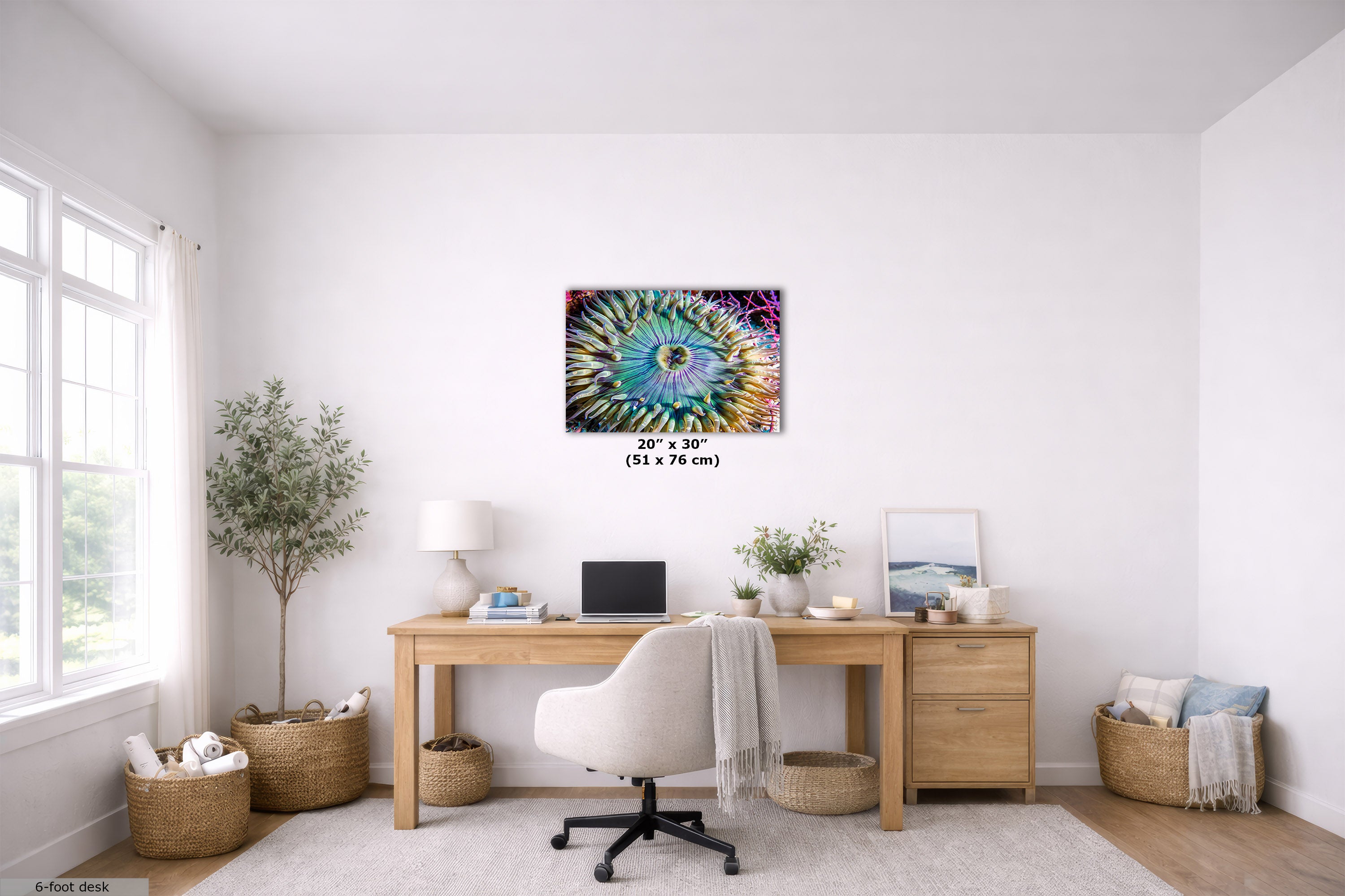 A colorful underwater abstract wall art print hangs above a wooden desk in a bright, modern home office. The print features a vibrant, swirling pattern with prominent shades of blue, green, purple, and yellow.