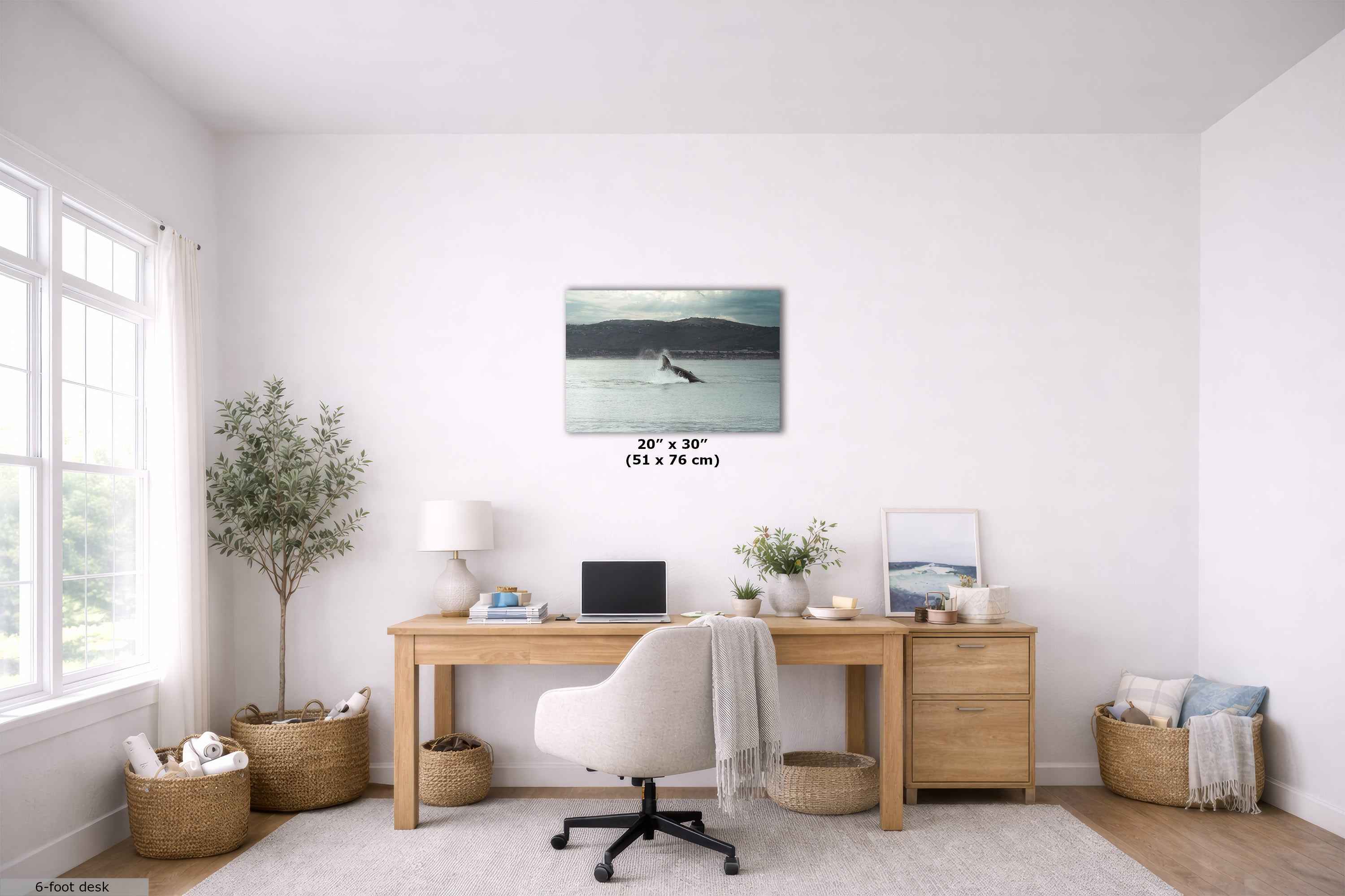 A 20x30 inch wall art print depicting a serene lake scene with a lone figure, displayed in a bright, modern home office setting above a wooden desk.
