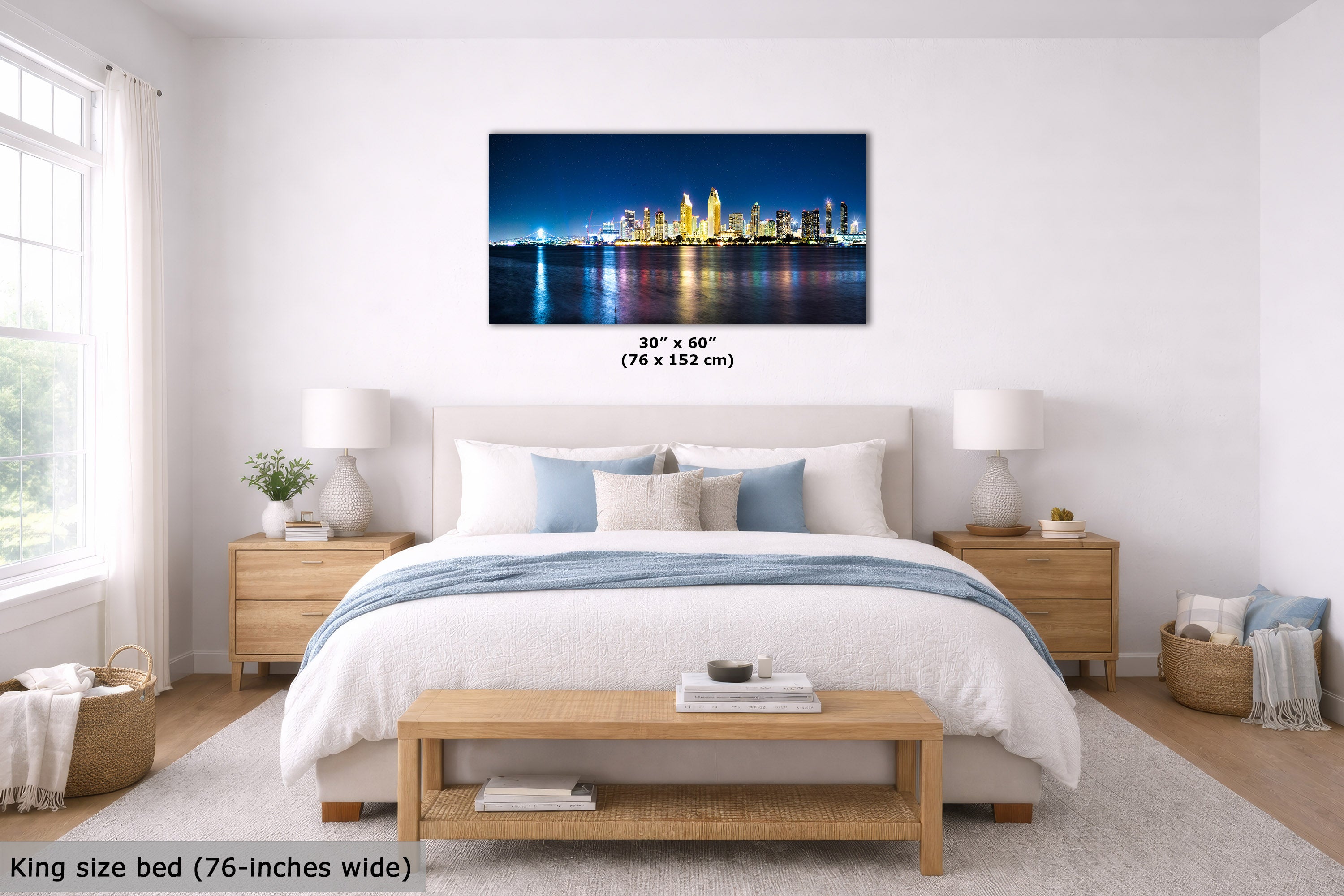 A framed wall art print showing a nighttime city skyline with glowing yellow buildings reflected in water, displayed above a neatly made bed in a bright, modern bedroom. Text on the image indicates the print size as 30 x 60 inches (76 x 152 cm) and notes the king size bed is 76 inches wide.