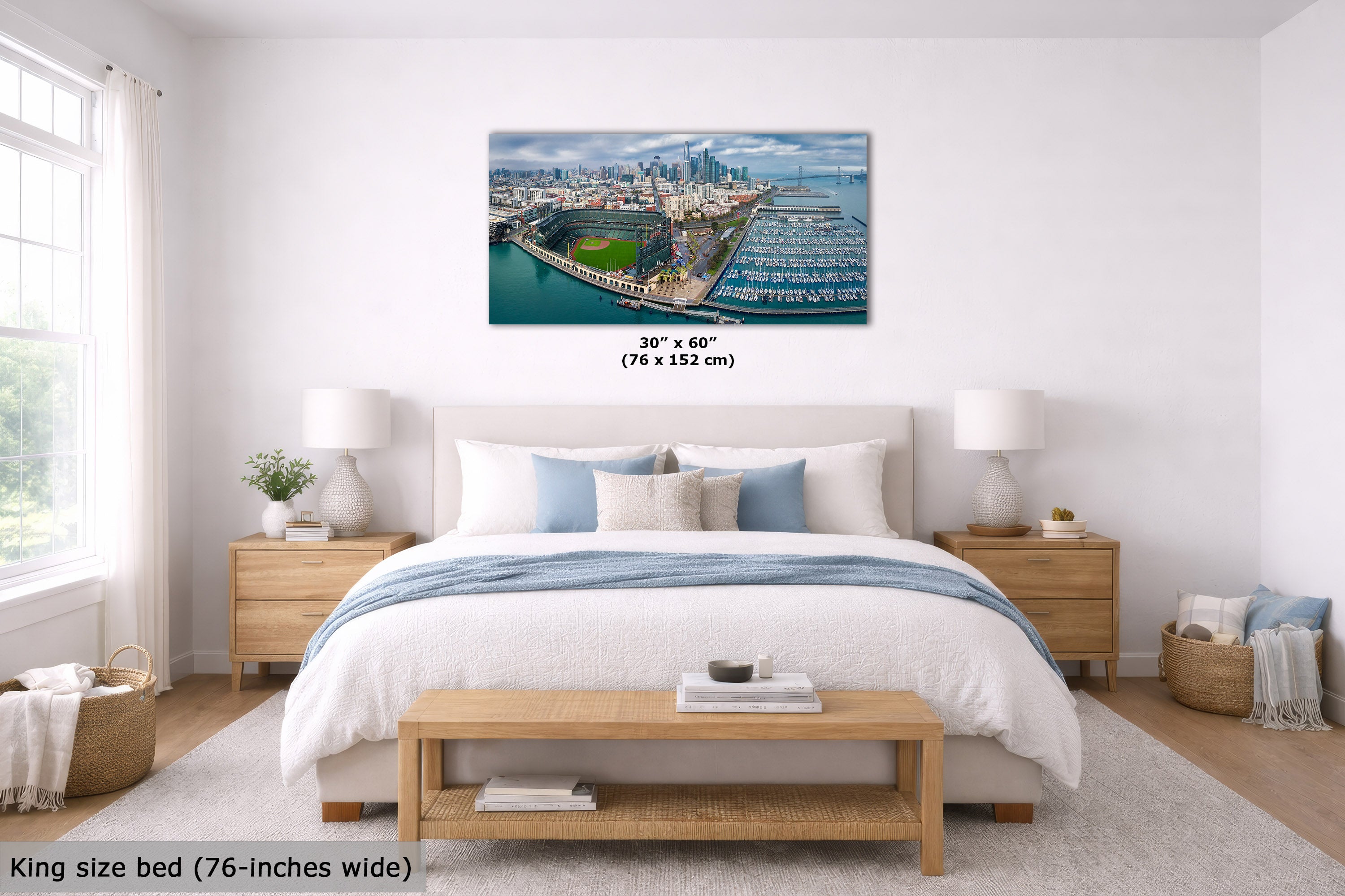 A wall art print showing an aerial view of the San Francisco Giants and the nearby marina is displayed above a neatly made bed in a bright, modern bedroom. The print includes a size label reading 30" x 60" (76 x 152 cm).