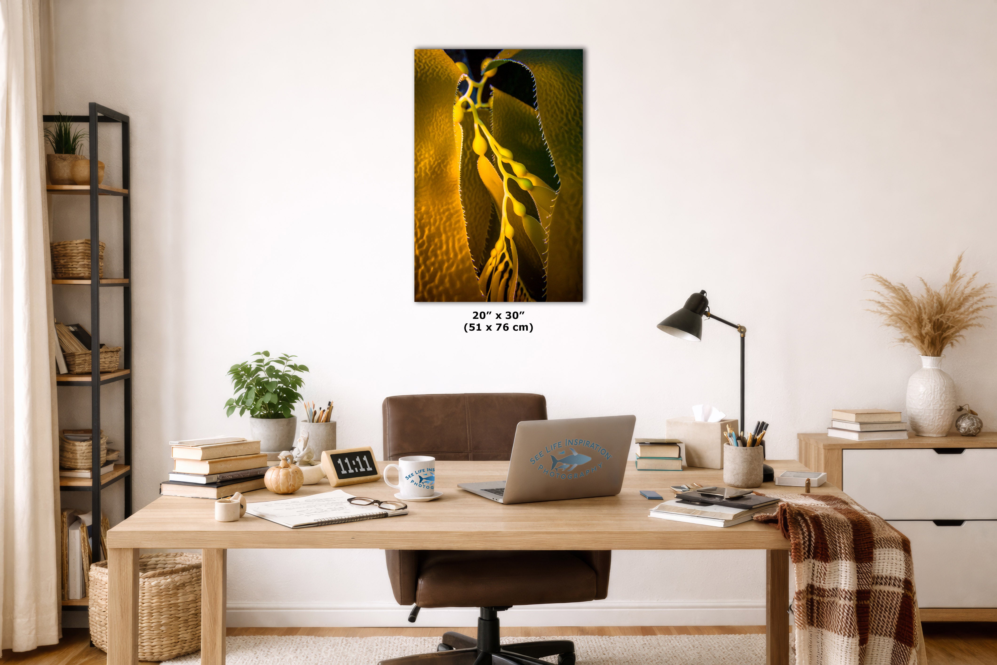A framed wall art print depicting a close-up of an underwater photograph displayed in a styled home office setting above a wooden desk with a laptop, lamp, and other decor items.