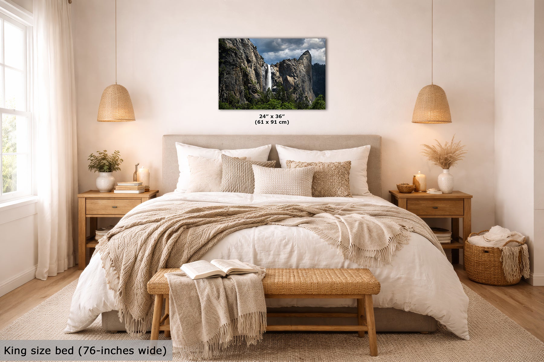 A wall art print showing Yosemite's Bridalveil Waterfall between tall rocky cliffs under a cloudy sky, displayed above a neatly made bed in a bright, neutral-toned bedroom. Small text below the print reads 24 x 36 inches, and text at the bottom left says King size bed (76-inches wide).