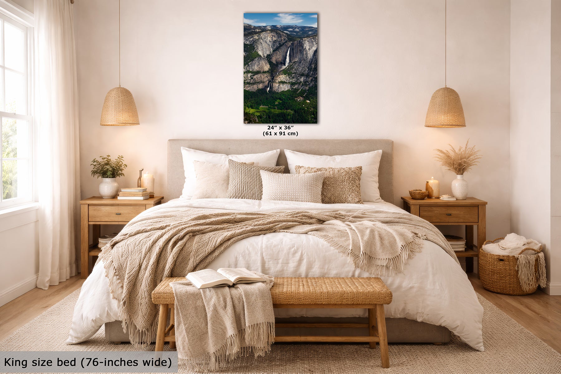 A framed wall art print depicting a mountain landscape with Yosemite Falls, shown hanging above a neatly made bed in a bright, modern bedroom. The print includes size text reading 24 x 36 inches, and the room scene includes a king size bed and text noting 76-inches wide.