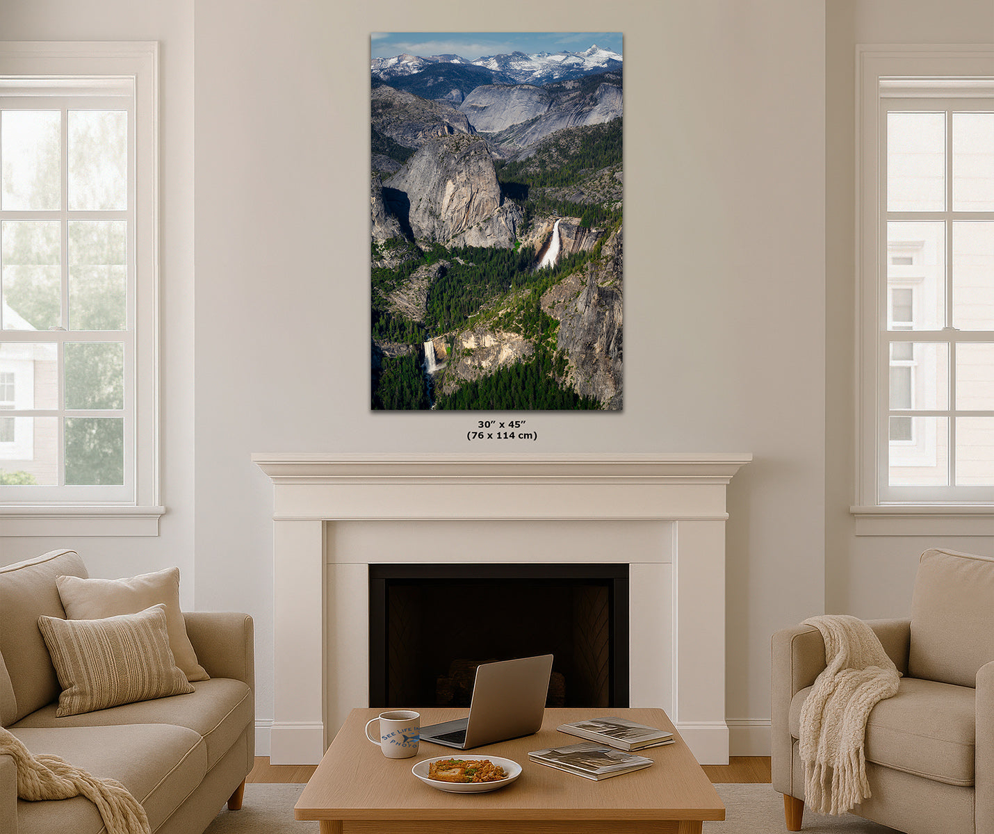 A vertical print of Yosemite Valley with mountains, forests, and waterfalls, displayed on a white fireplace mantel in a modern living room setting. The dimensions '30" x 60" (76 x 114 cm)' are printed below the canvas.
