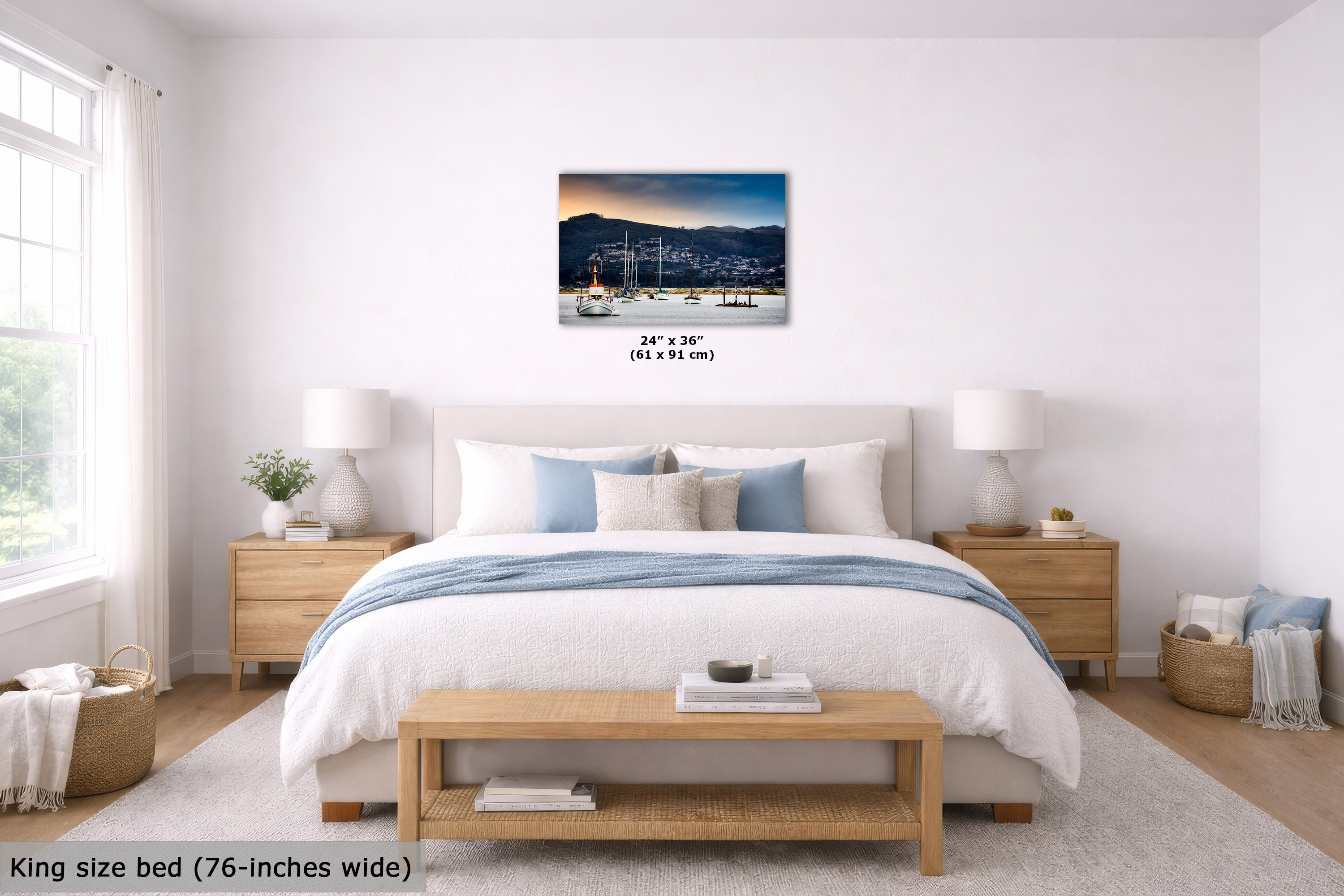 A wall art print showing a harbor sunset with boats is displayed above a neatly made bed in a bright, modern bedroom. The print includes size text reading 24" x 36" (61 x 91 cm).