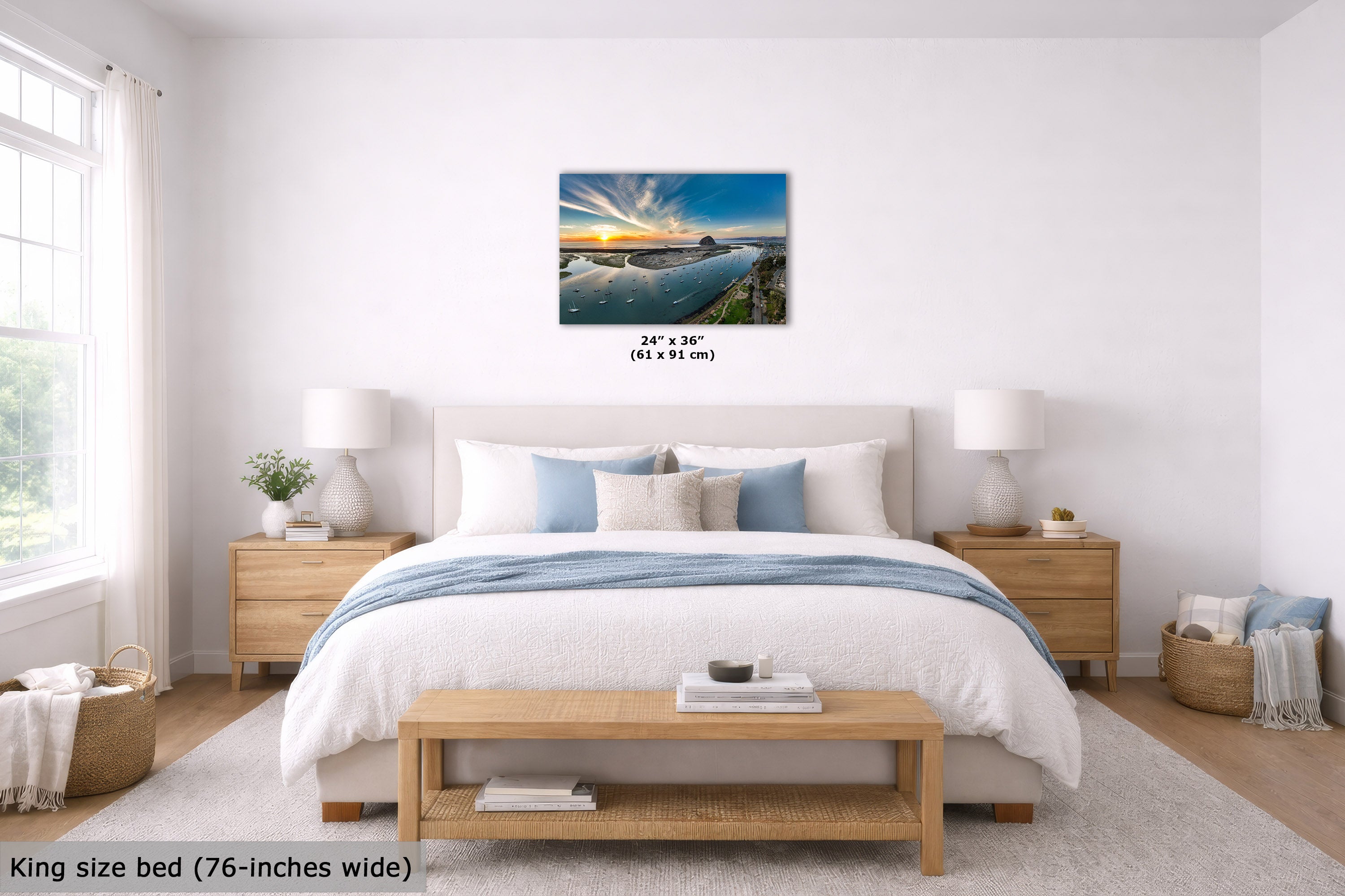 A wall art print showing a sunset over calm water, displayed above a neatly made bed in a bright, modern bedroom. The print includes size text reading 24" x 36" (61 x 95 cm), and the room scene includes a text overlay noting the bed is king size (76-inches wide).