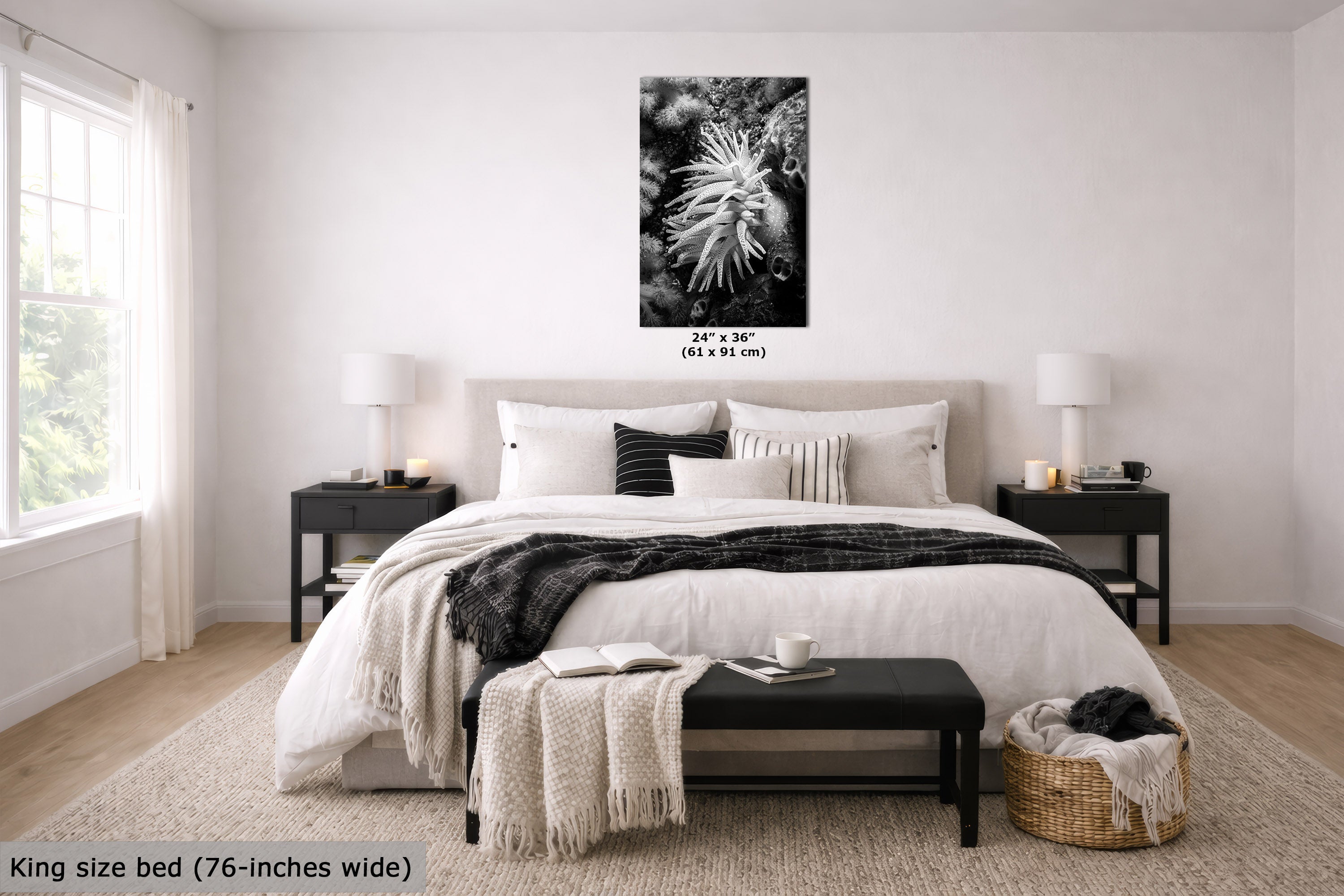 A black and white floral wall art print displayed above a neatly made bed in a bright, modern bedroom. The print features a close-up of a flower with text indicating its dimensions as 24" x 36" (61 x 91 cm).