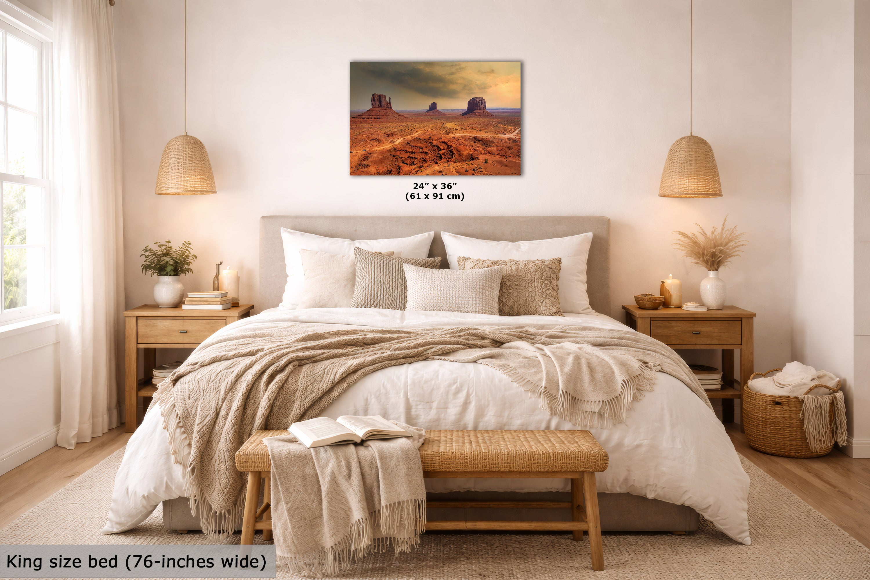 A desert landscape wall art print hangs above a neatly made bed in a bright, modern bedroom. The print shows red rock desert formations under a dramatic sky.