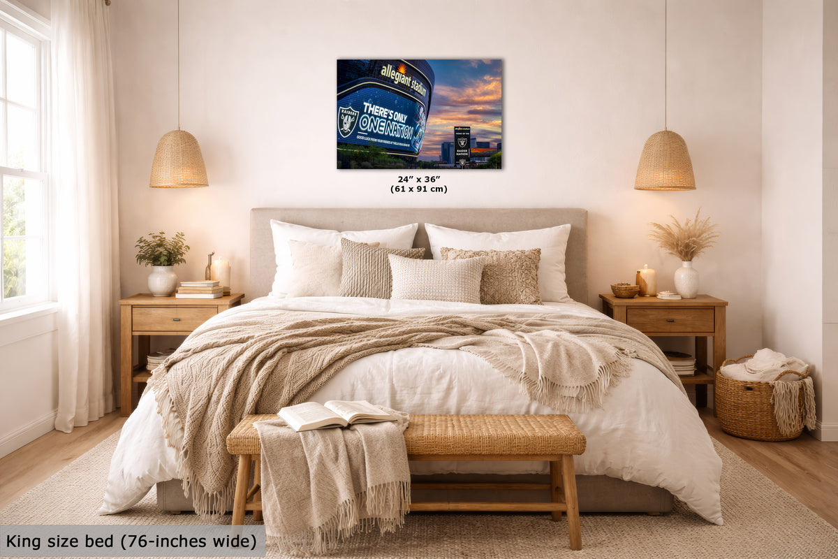 A wall art print showing the Allegiant Stadium scene in Las Vegas at sunset, displayed above a neatly made bed in a bright, modern bedroom. The print includes size text reading 24 x 36 inches (61 x 91 cm), and the room scene includes a text overlay noting the king size bed is 76-inches wide.