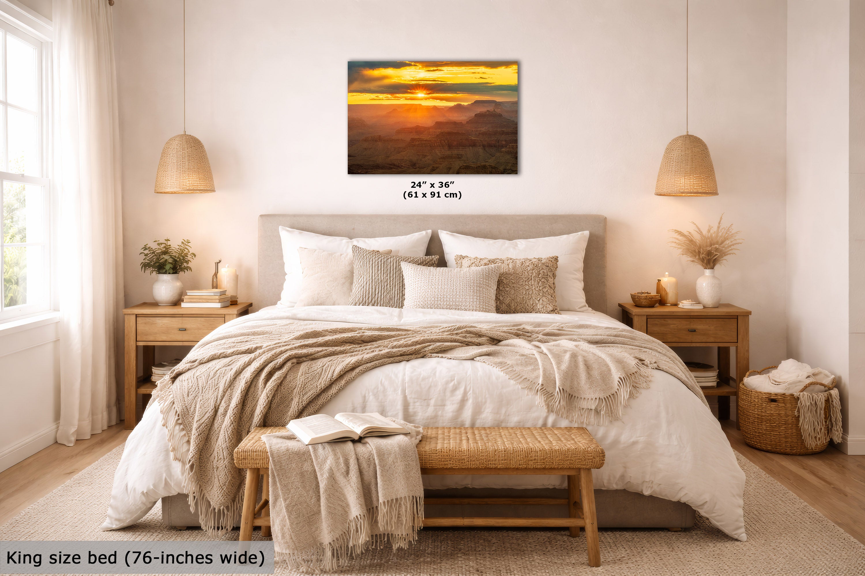 A wall art print showing a golden sunset over mountain ridges, displayed above a neatly made bed in a bright, modern bedroom. The print includes size text reading 24 x 36 inches (61 x 91 cm), and the room scene also includes a bed, nightstands, lamps, and decorative textiles.