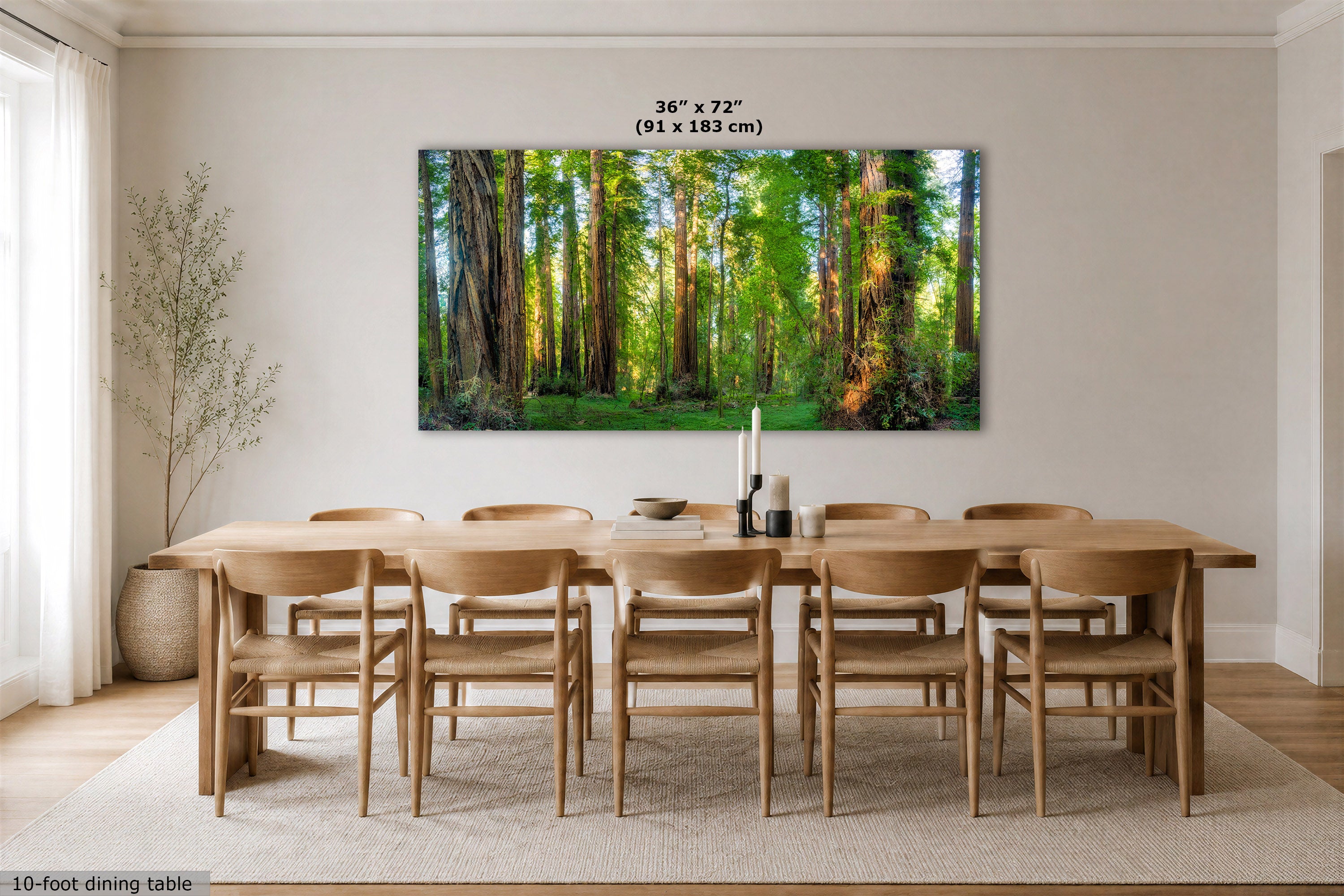 A large rectangular wall art print showing a sunlit forest of tall trees, displayed above a wooden dining table and chairs in a bright dining room. Text above the artwork reads 36 x 72" (91 x 183 cm).