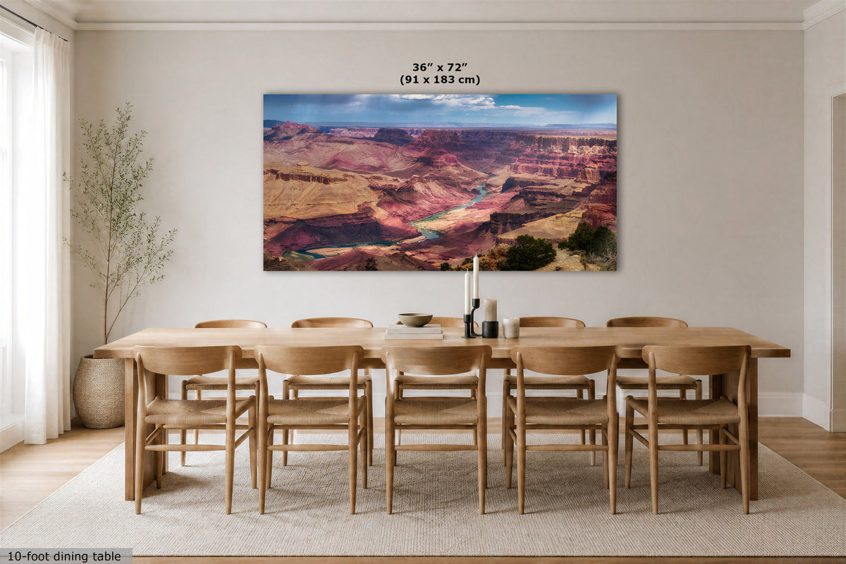 A large rectangular wall art print depicting the Grand Canyon is displayed above a wooden dining table and chairs in a bright, modern dining room. The print includes a size label reading 36 x 72 (91 x 183 cm) at the top.