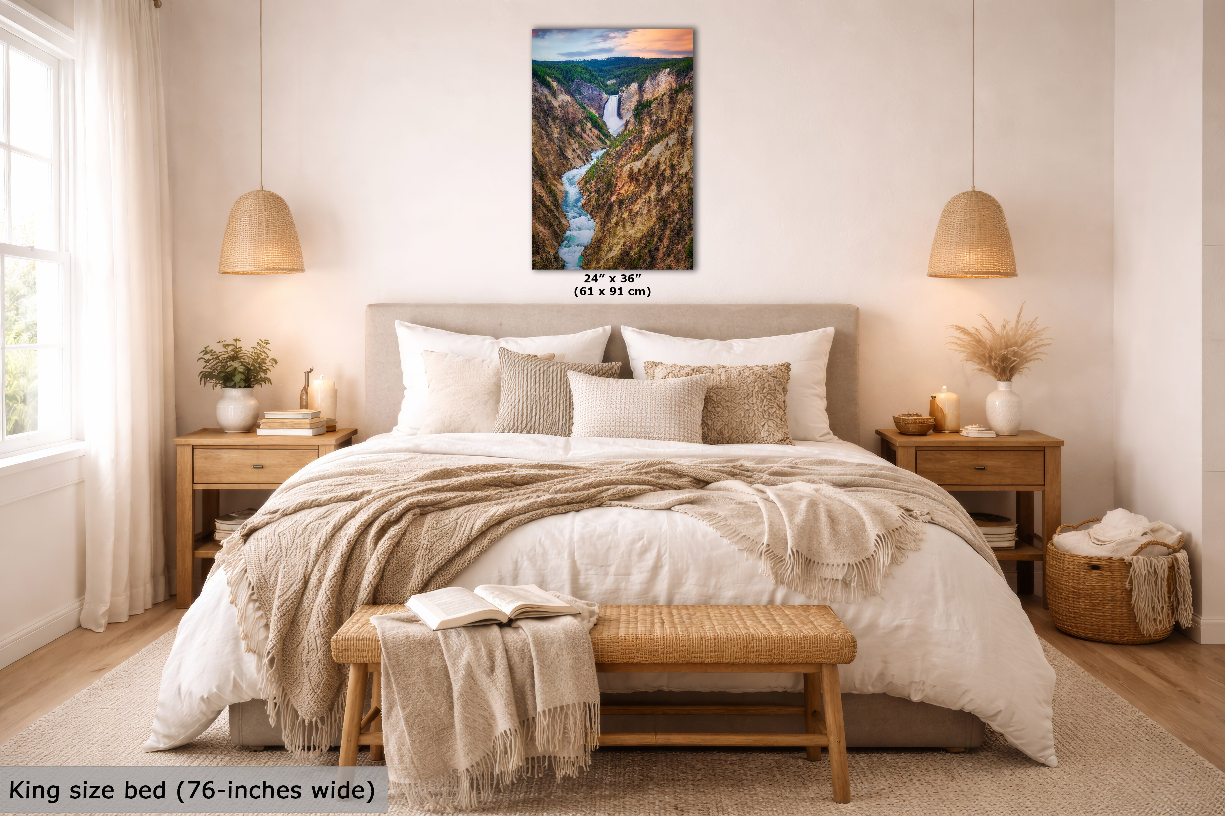A framed landscape wall art print showing a canyon river scene, displayed above a neatly made bed in a bright, modern bedroom. The print includes size text reading 24 x 36 inches (61 x 91 cm).