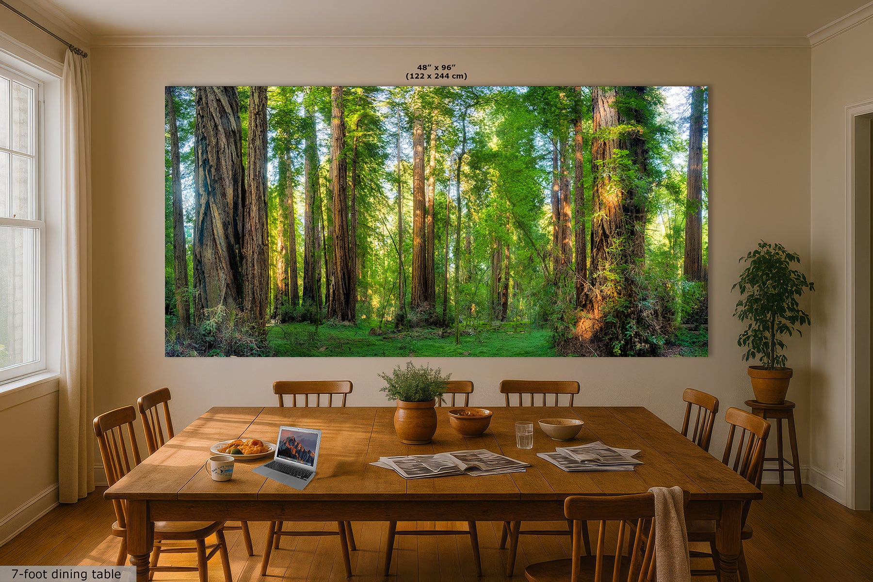 A large wall art print depicting a sunlit California redwood forest is displayed above a wooden dining table in a real dining room. The print includes size text at the top reading 48 x 96 inches (122 x 244 cm).