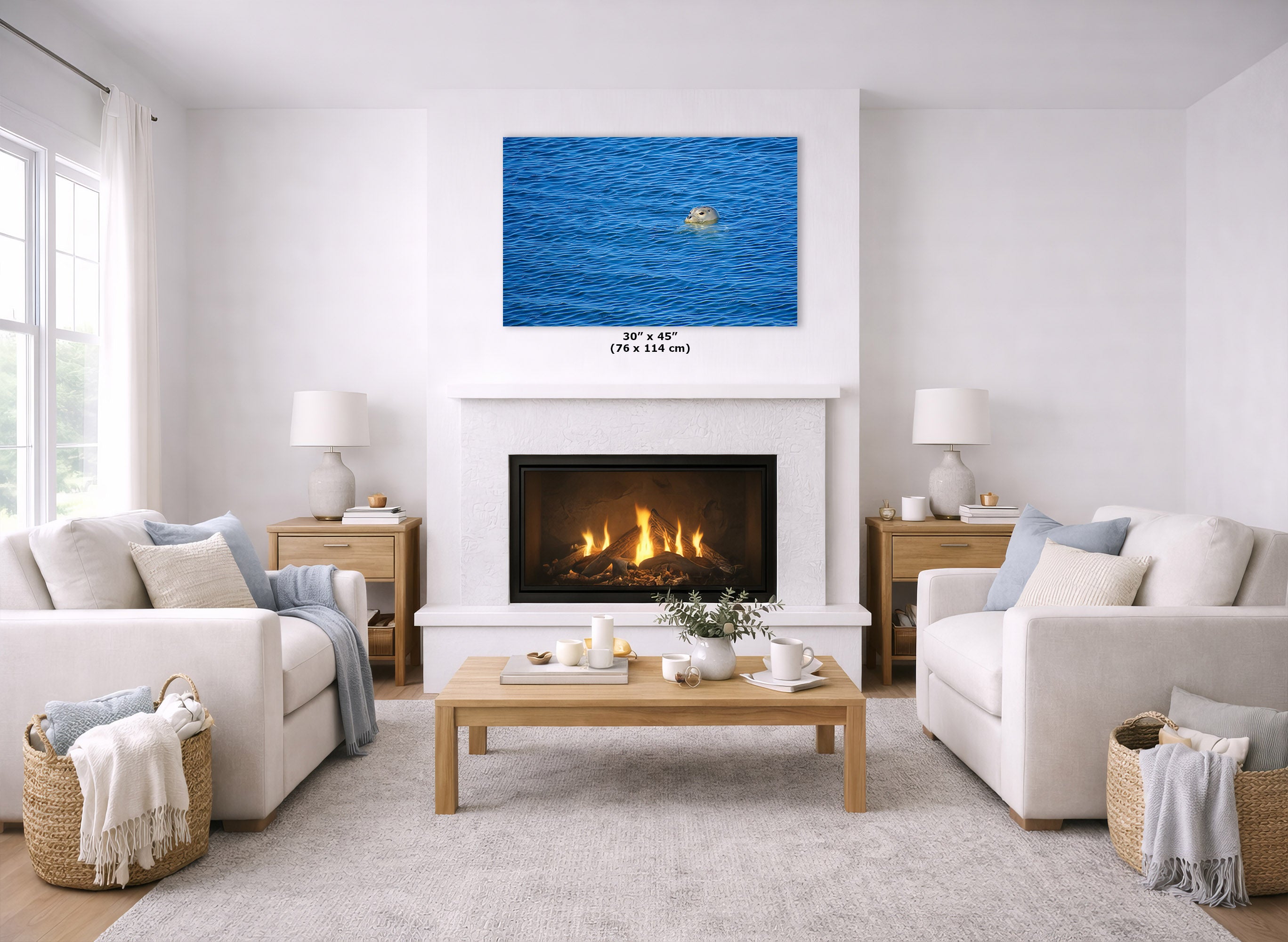 A modern living room featuring a large square canvas print of a grey seal swimming in the blue ocean, mounted above a white fireplace. The room is styled with two cream-colored sofas, a wooden coffee table, and a light gray rug.