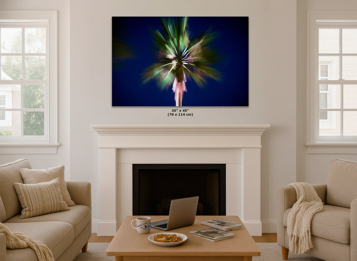 A wall art print showing a colorful palm tree silhouette on a dark blue background, displayed above a white fireplace mantel in a bright living room. Small text below the frame indicates dimensions 30 x 45 in (76 x 114 cm).