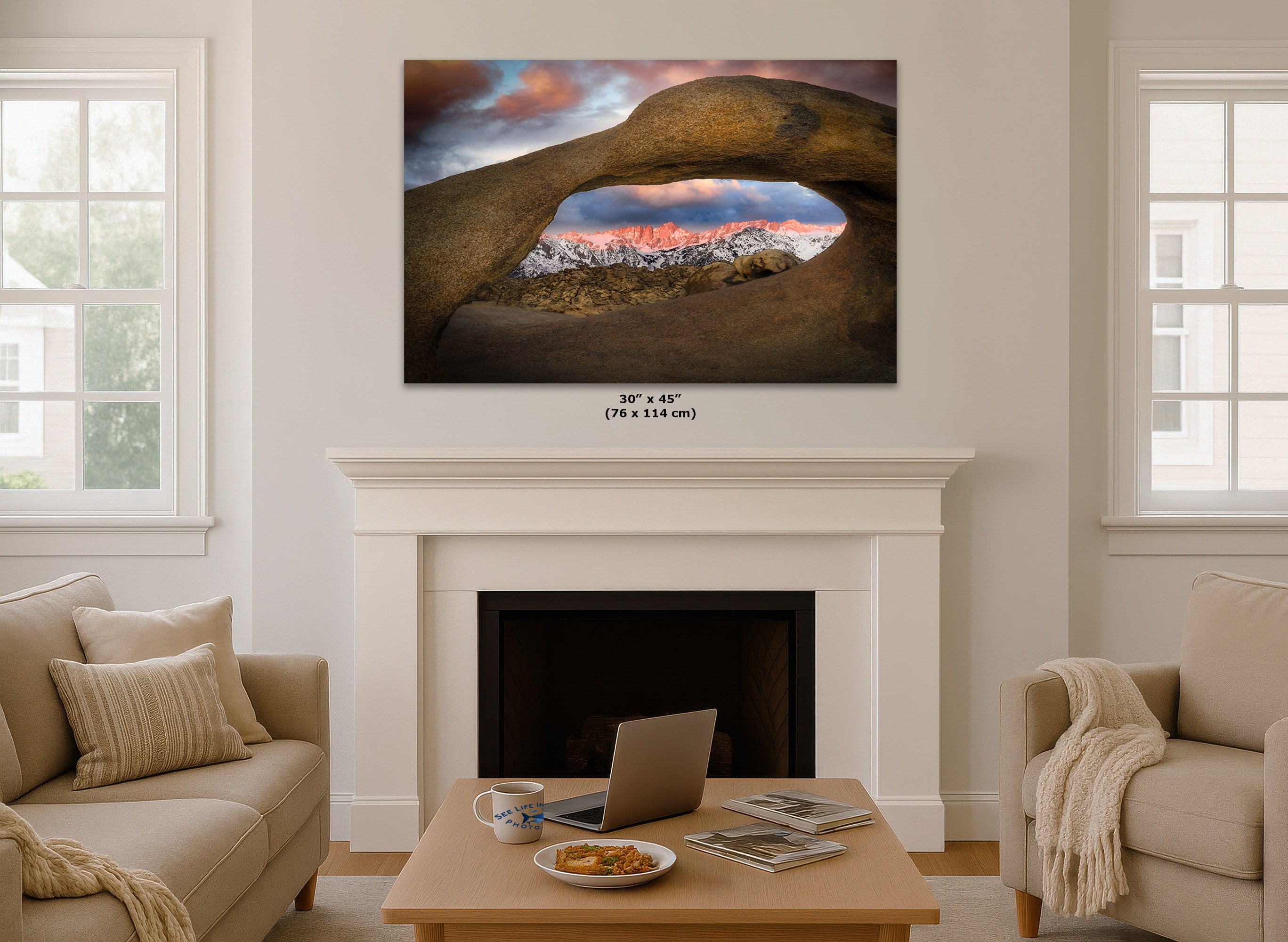 Living room with a wall art print displaying a scenic landscape looking through Mobius Arch at the Alabama Hills, hung over a fireplace.