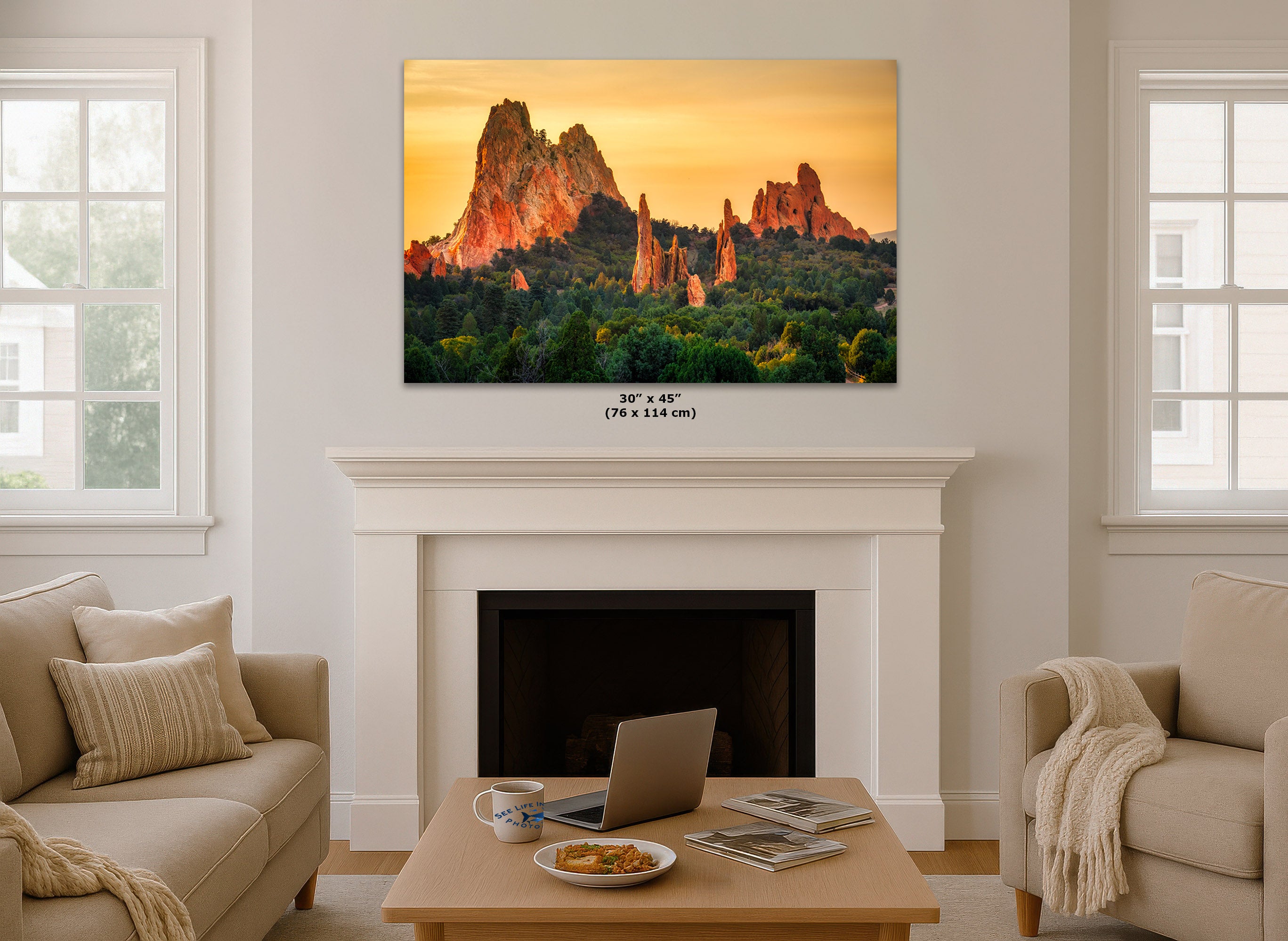 A wall art print showing a desert rock landscape at sunset hangs above a white fireplace in a bright living room. The print is labeled 30 x 45 inches (76 x 114 cm) below it.