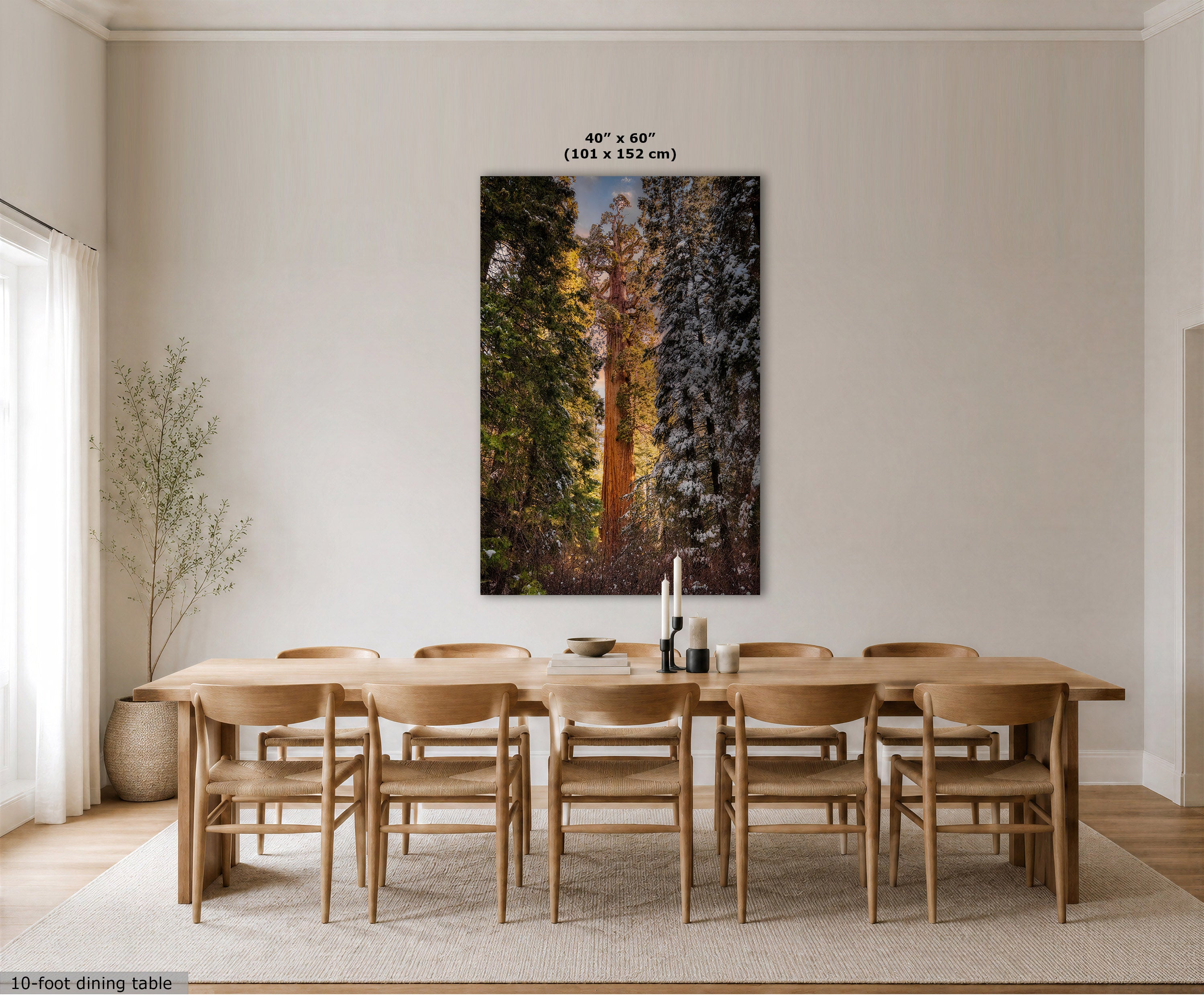 A large vertical wall art print showing a forest with tall golden trees and dark conifers, displayed above a wooden dining table and chairs in a bright neutral dining room. Text at the top indicates the print size as 40 x 60 inches (101 x 152 cm).