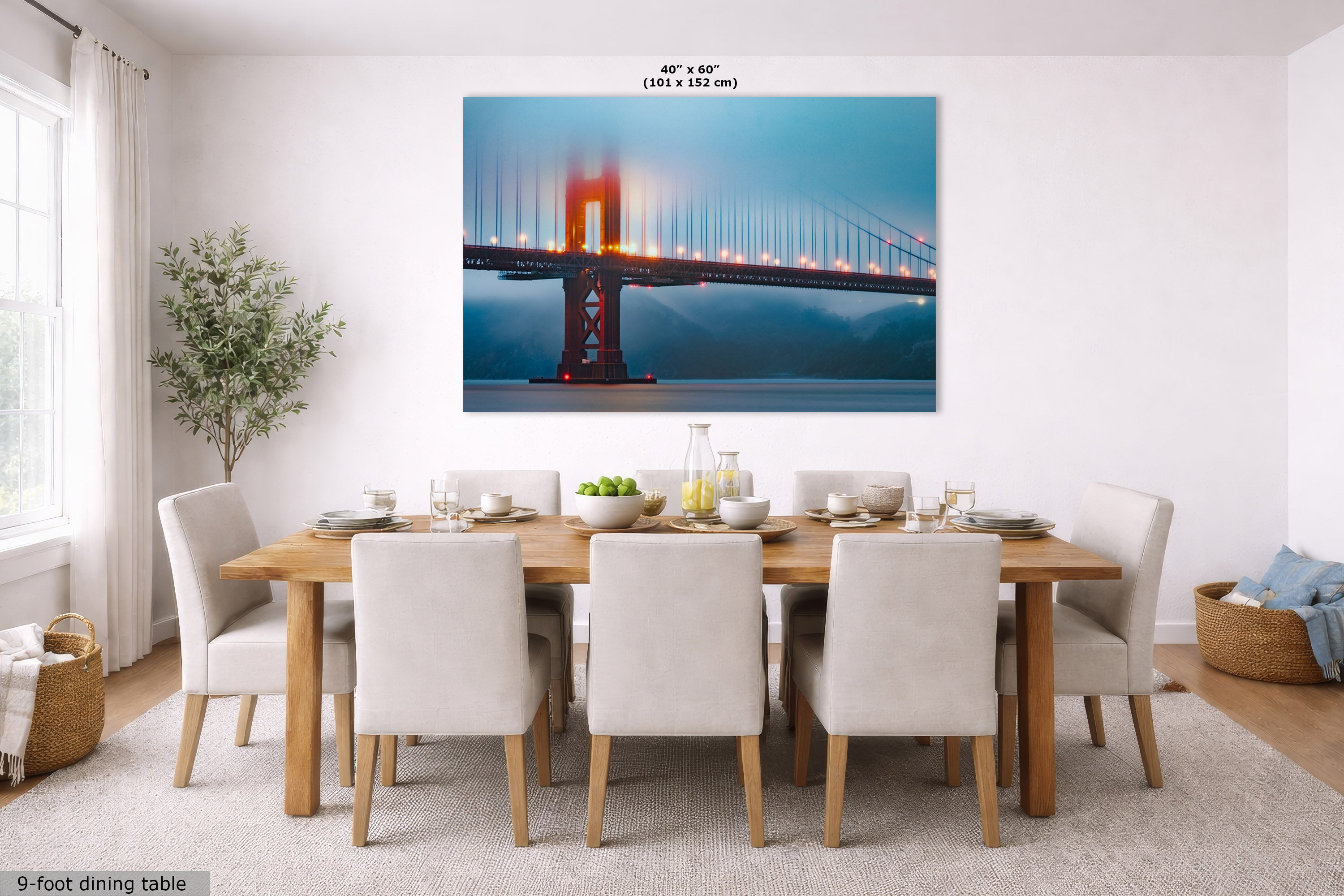 A large rectangular wall art print showing the Golden Gate Bridge at dusk, displayed above a dining table in a bright modern dining room. The print is labeled 40 x 60 inches, and the room scene includes chairs, a table, window, and plant.
