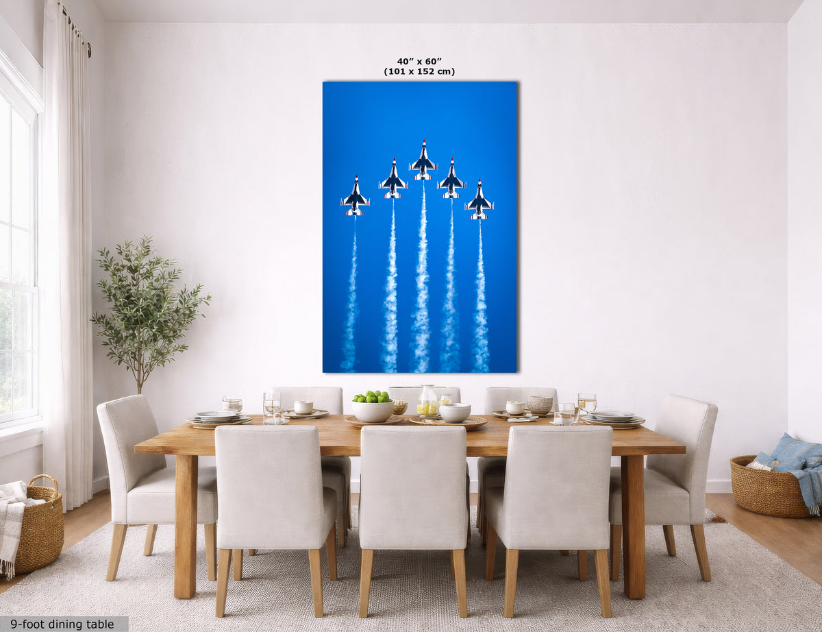 A large canvas wall art print depicting five fighter jets flying in a bright blue sky with white contrails, displayed in a modern dining room setting above a wooden dining table and chairs. The image includes size text at the top and a small label at the bottom left.