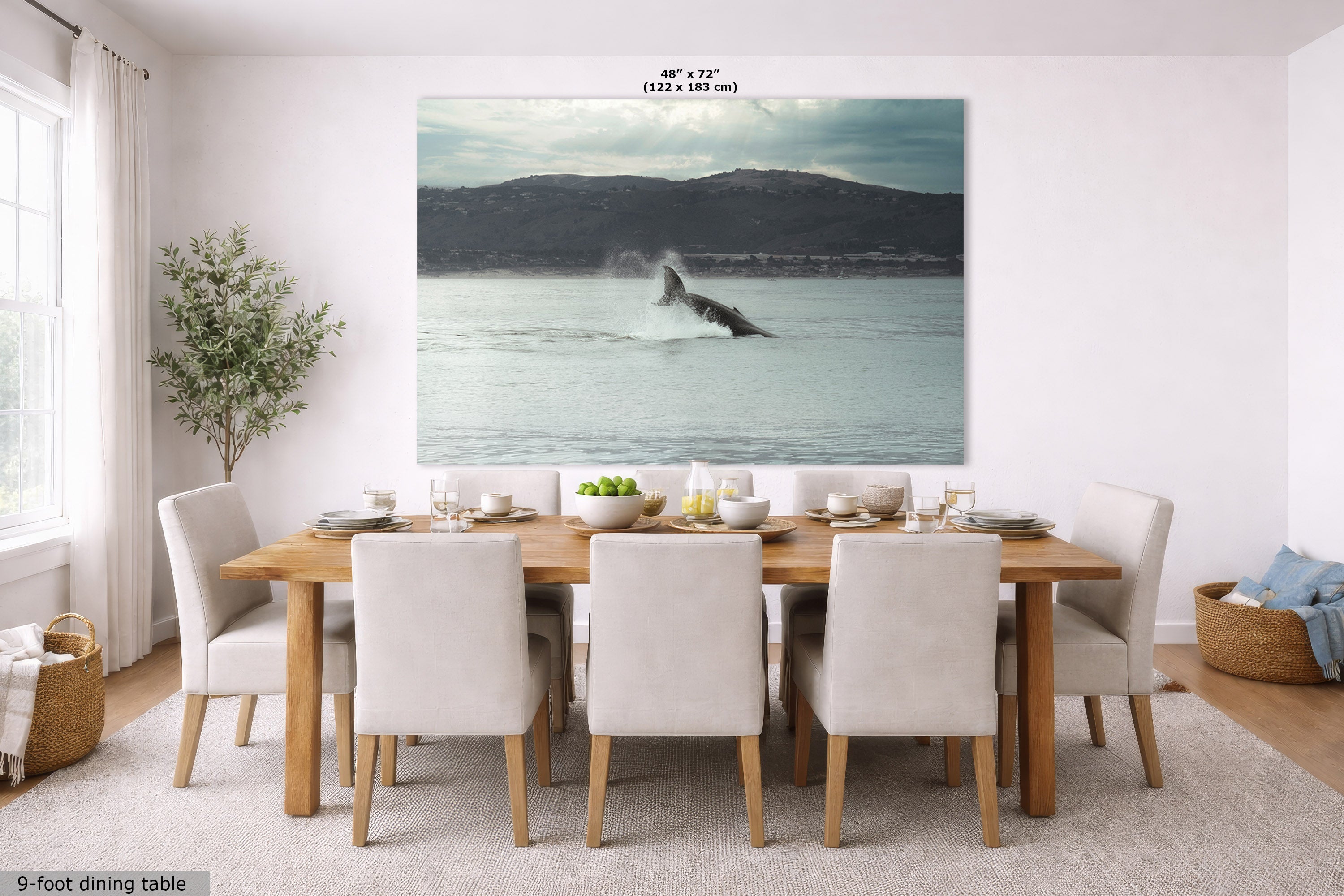 A large wall art print showing a whale breaching in the ocean, displayed in a dining room setting above a wooden dining table and chairs. The print has a text overlay indicating its dimensions as 48" x 72" (122 cm x 183 cm) and a note at the bottom left reading '9-foot dining table'.