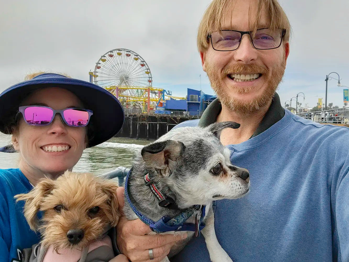 Jamie and Neil Peterson with their dogs Molly and Pixie with the Santa Monica pier in the backgroun