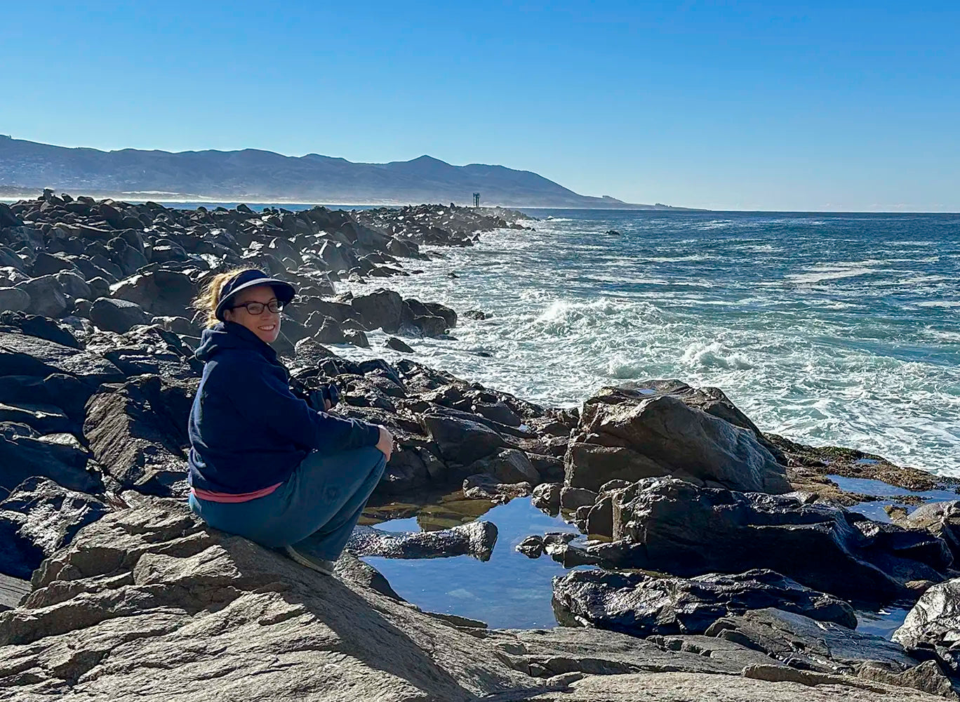 Jamie Lee Peterson sitting on the jetty at the beach