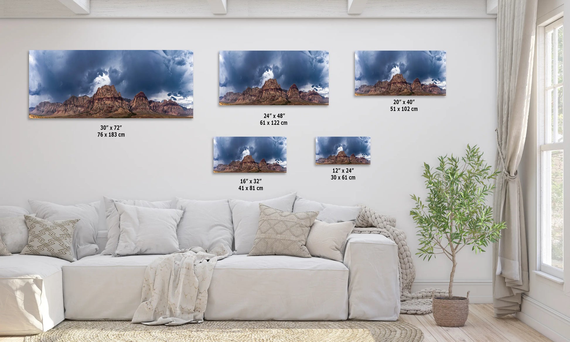 a living room with a white couch and three pictures on the wall