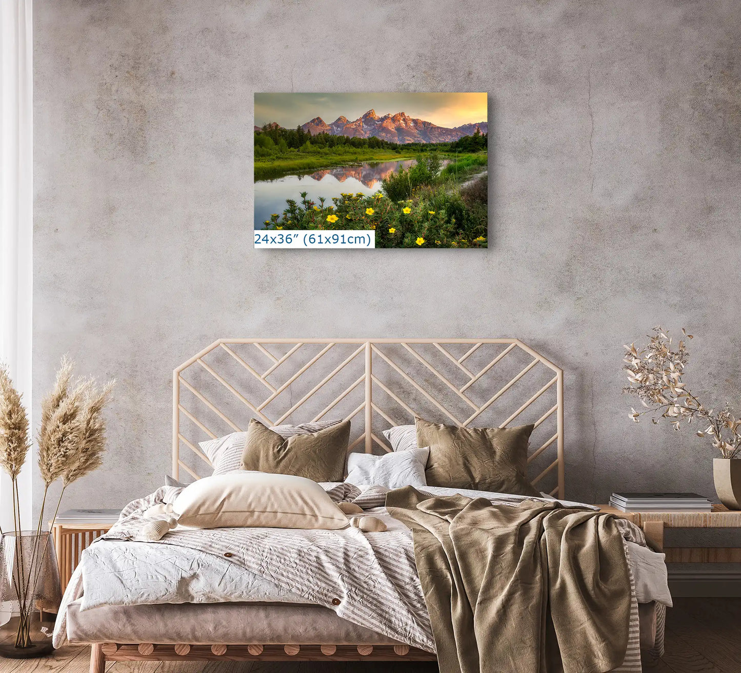 A 24x36 inch canvas print above a bed, featuring the Grand Teton Mountains at sunrise with yellow wildflowers, blending with the bedrooms decor.