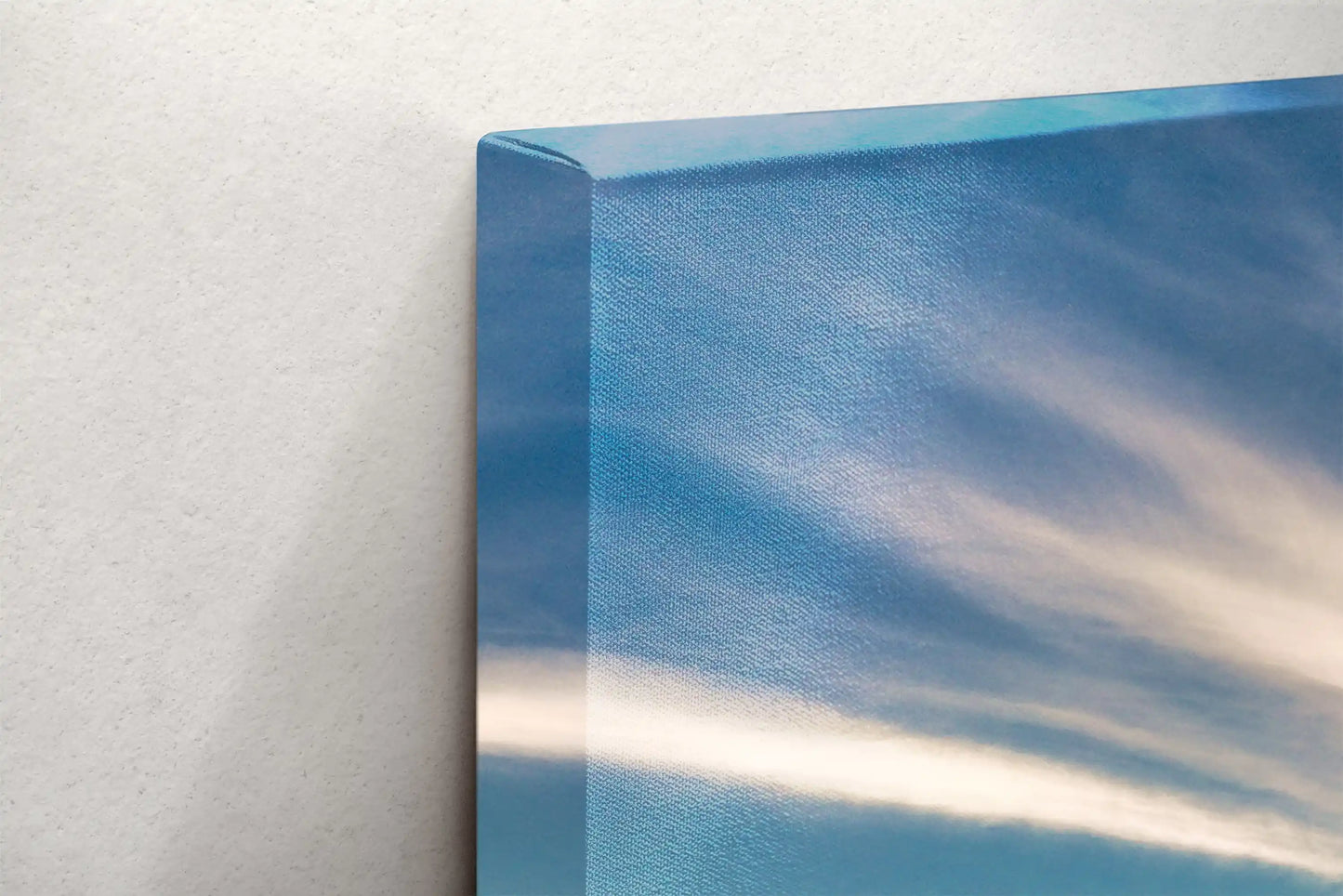 Edge of a canvas print showcasing a detailed aerial view of Morro Bay at sunset, with textured clouds and calm waters reflecting the serene California coast.