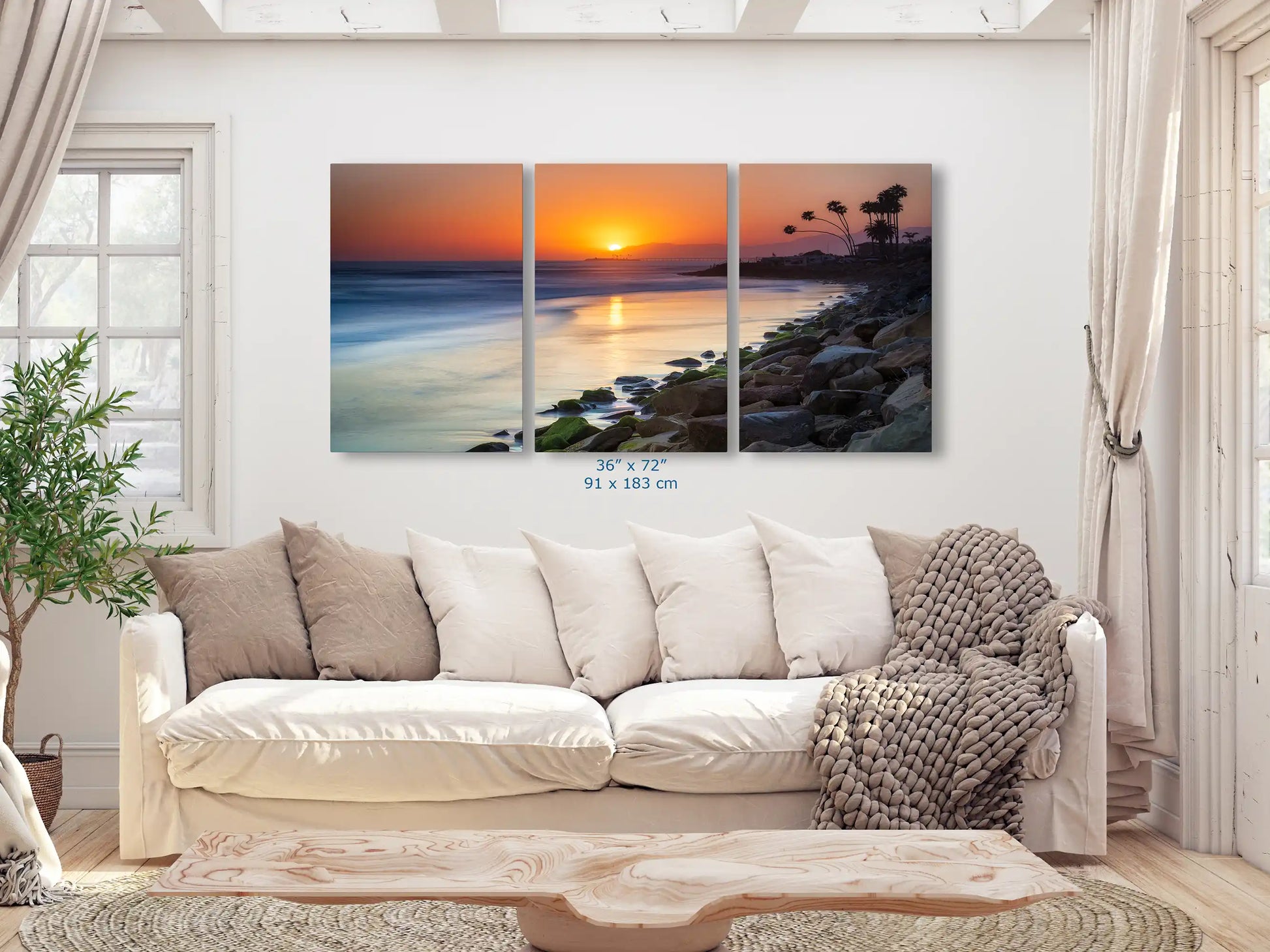Large 36"x72" canvas print of Ventura Beach sunset, spanning across the living room wall for a dramatic visual impact.