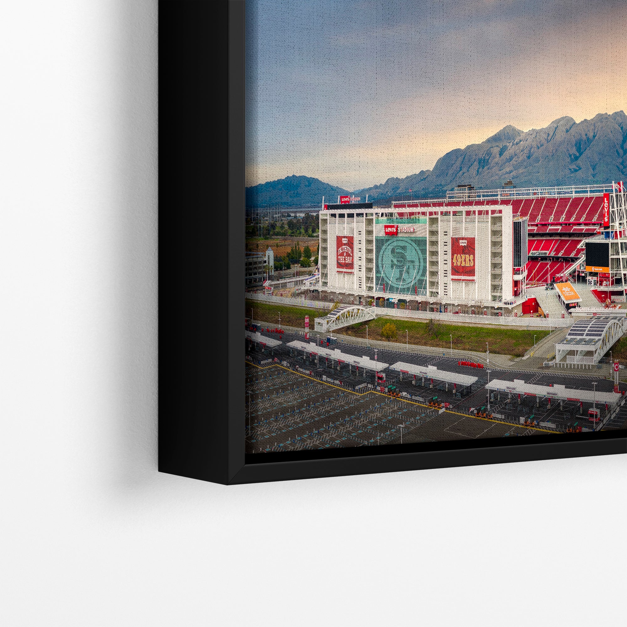 a large stadium with a mountain range in the background, featuring a large circular logo on the side of the stadium.