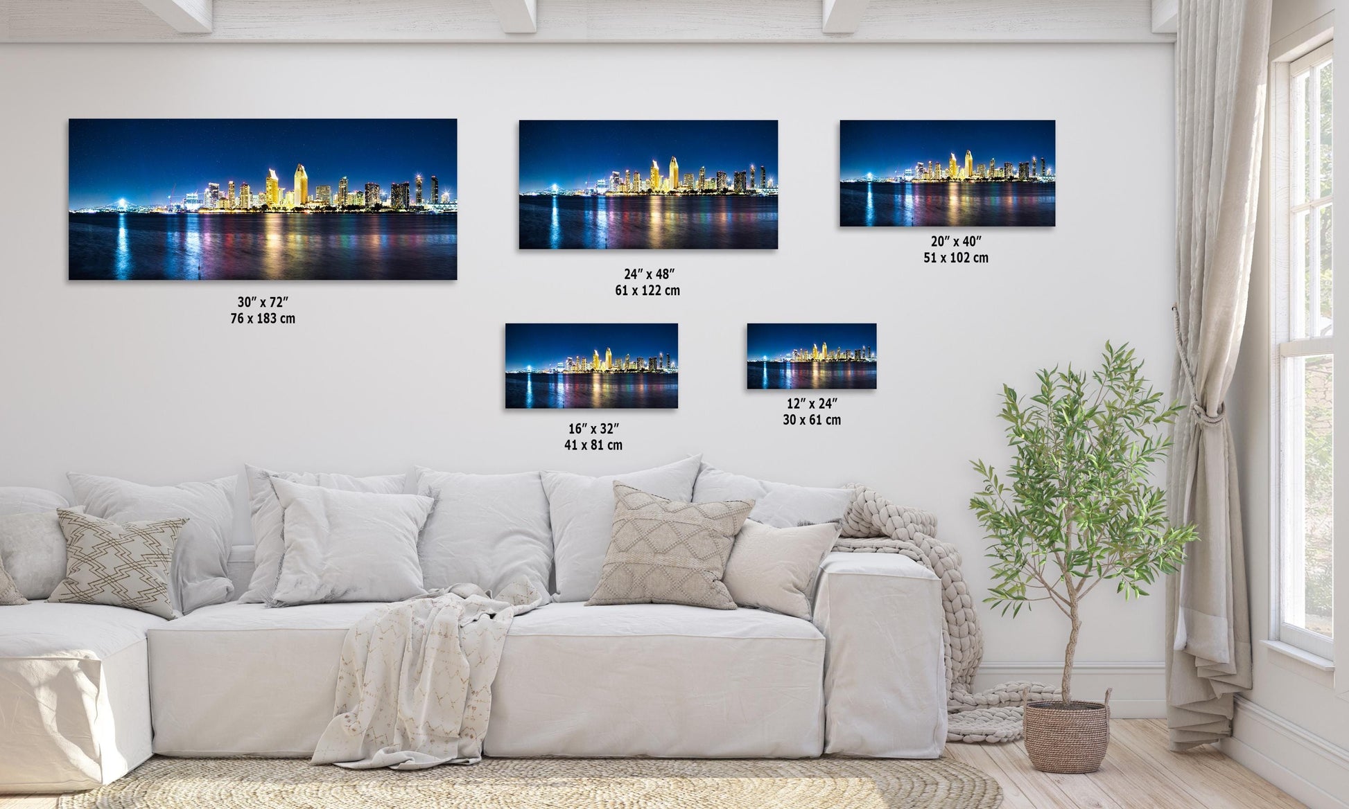 San Diego skyline wall art displayed in various sizes on a living room wall, featuring the city's buildings and their reflections on the water at night.