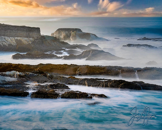 Dramatic California coastline with rocks amidst foggy waters, a dreamy image that soothes the soul