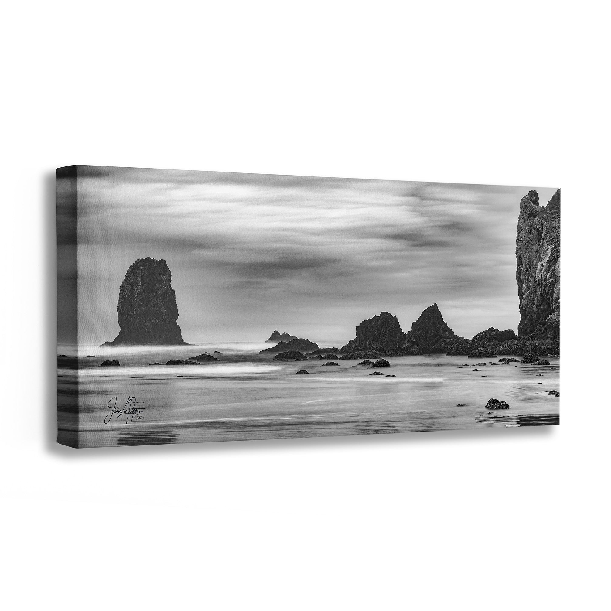 A black and white panoramic canvas wall art print depicting coastal sea stacks and rocks over a misty shoreline, shown at an angle against a white background.