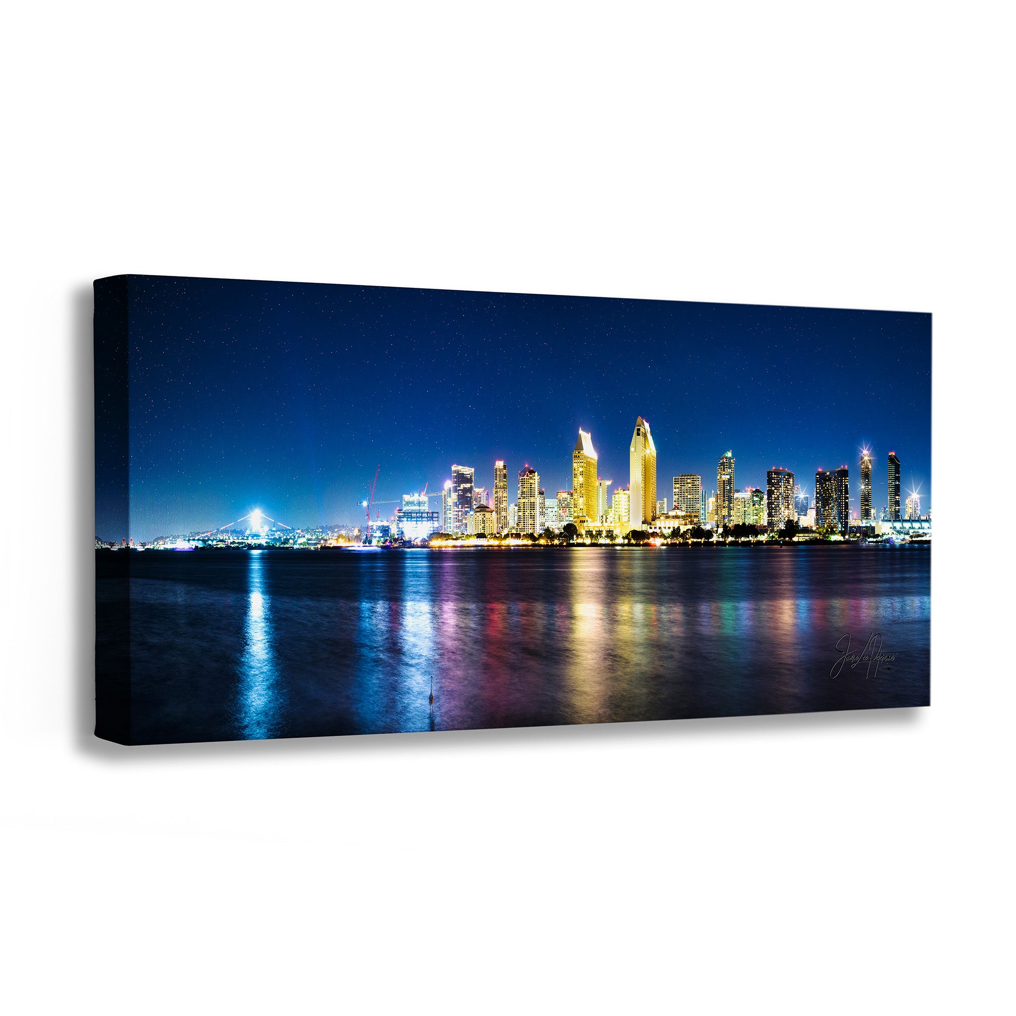 A panoramic canvas wall art print depicting a vibrant city skyline at night with illuminated skyscrapers reflecting on water, shown as a three-dimensional gallery wrap on a white background.