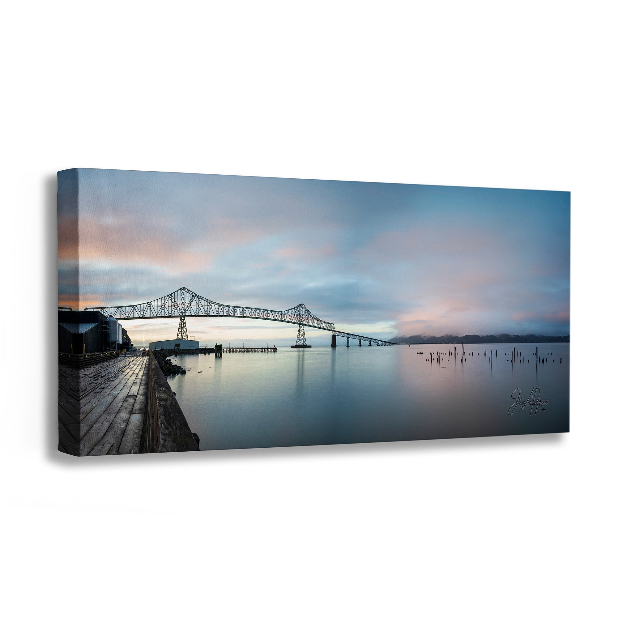 A rectangular canvas wall art print showing a waterfront scene with a bridge over calm water under a pastel sky, photographed against a plain white background.