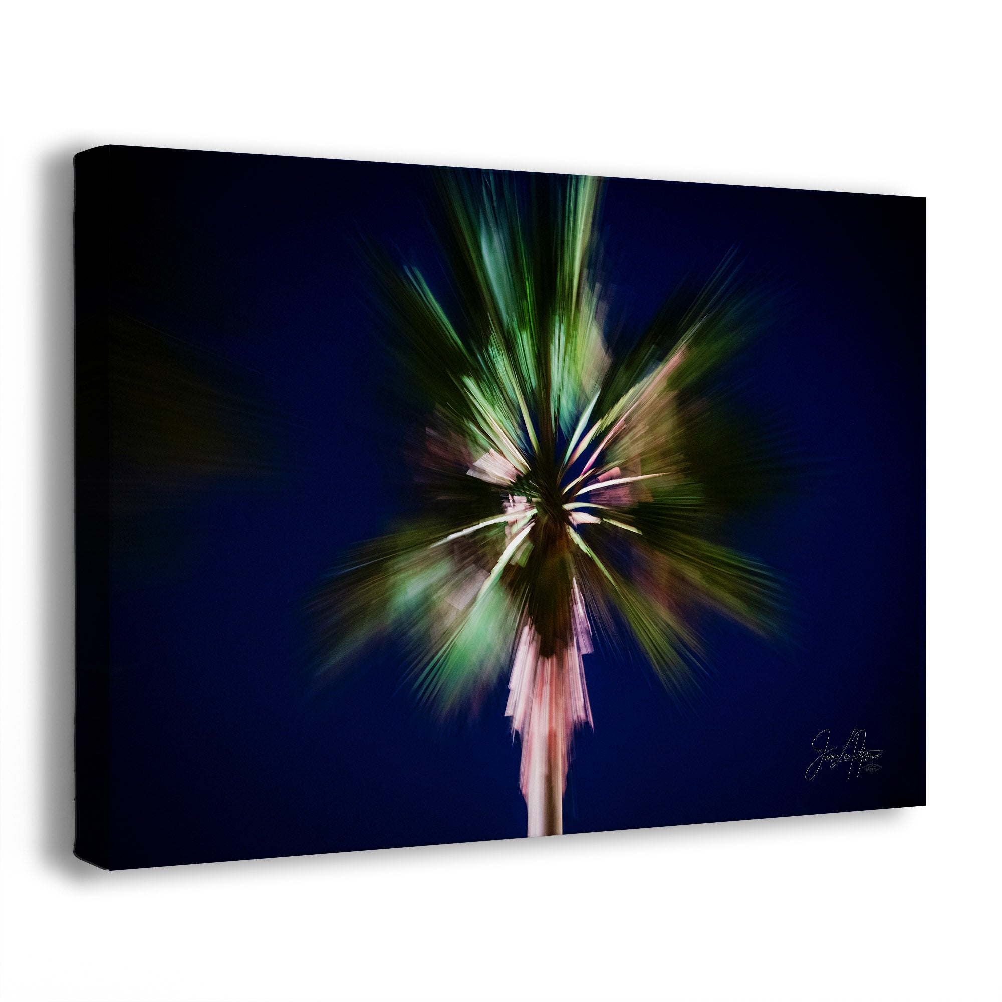 A canvas wall art print featuring an abstract, motion-blurred palm tree in green, pink, and white against a deep navy blue background, shown at a three-quarter angle on a white studio background.