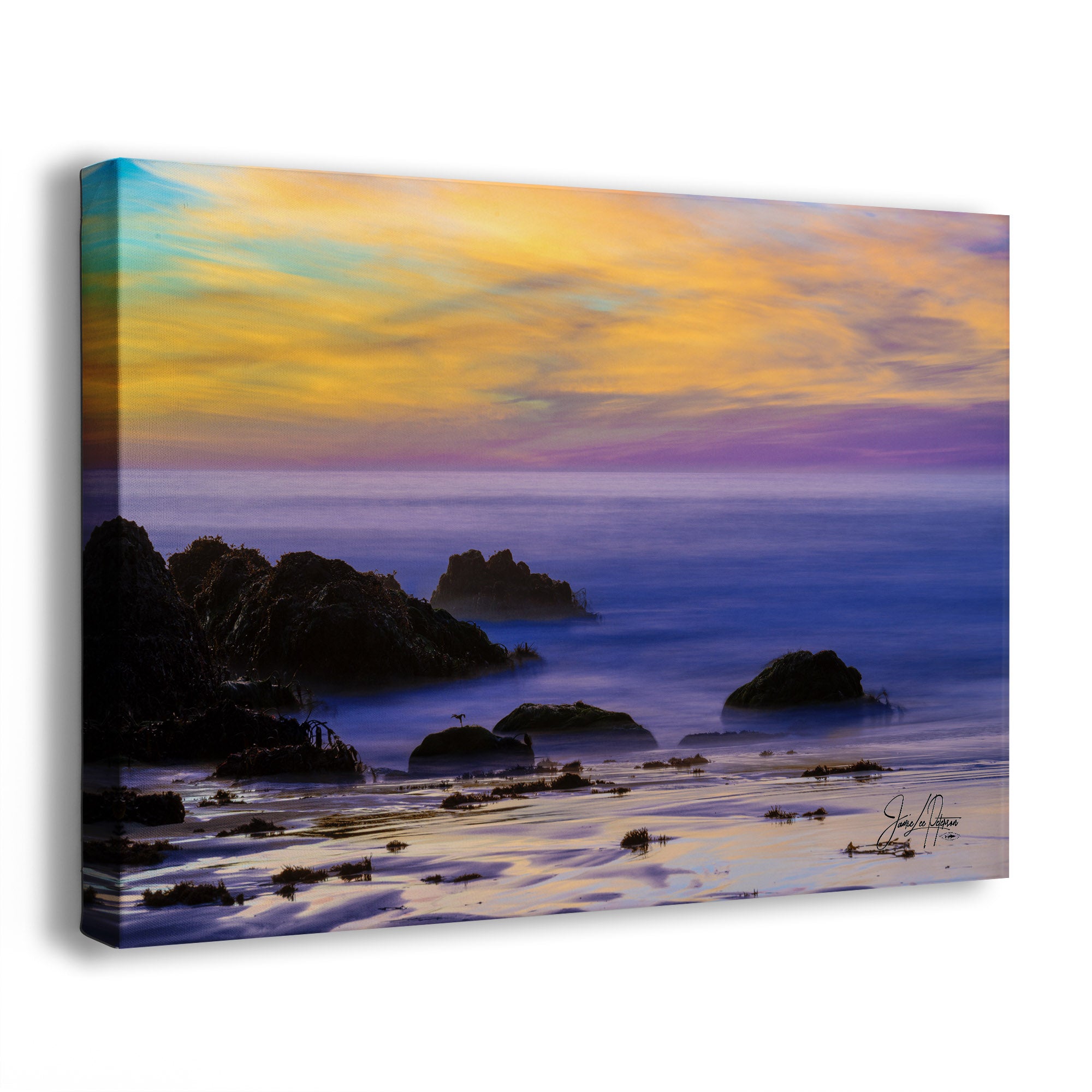 Canvas print of a Big Sur, California, coastal sunset scene with rocks a misty ocean, and a colorful sky.