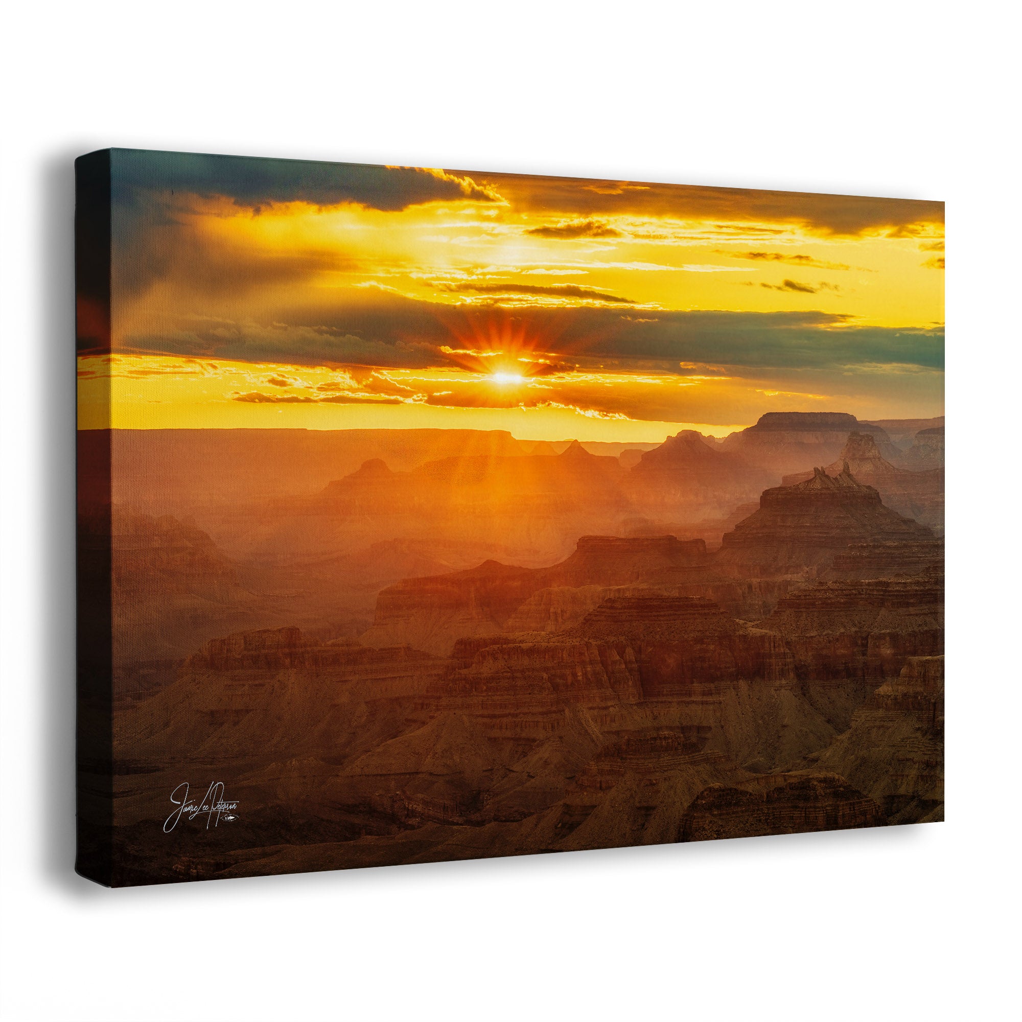 A side view of a canvas wall art print of a cloudy yellow sunset of the Grand Canyon landscape. 